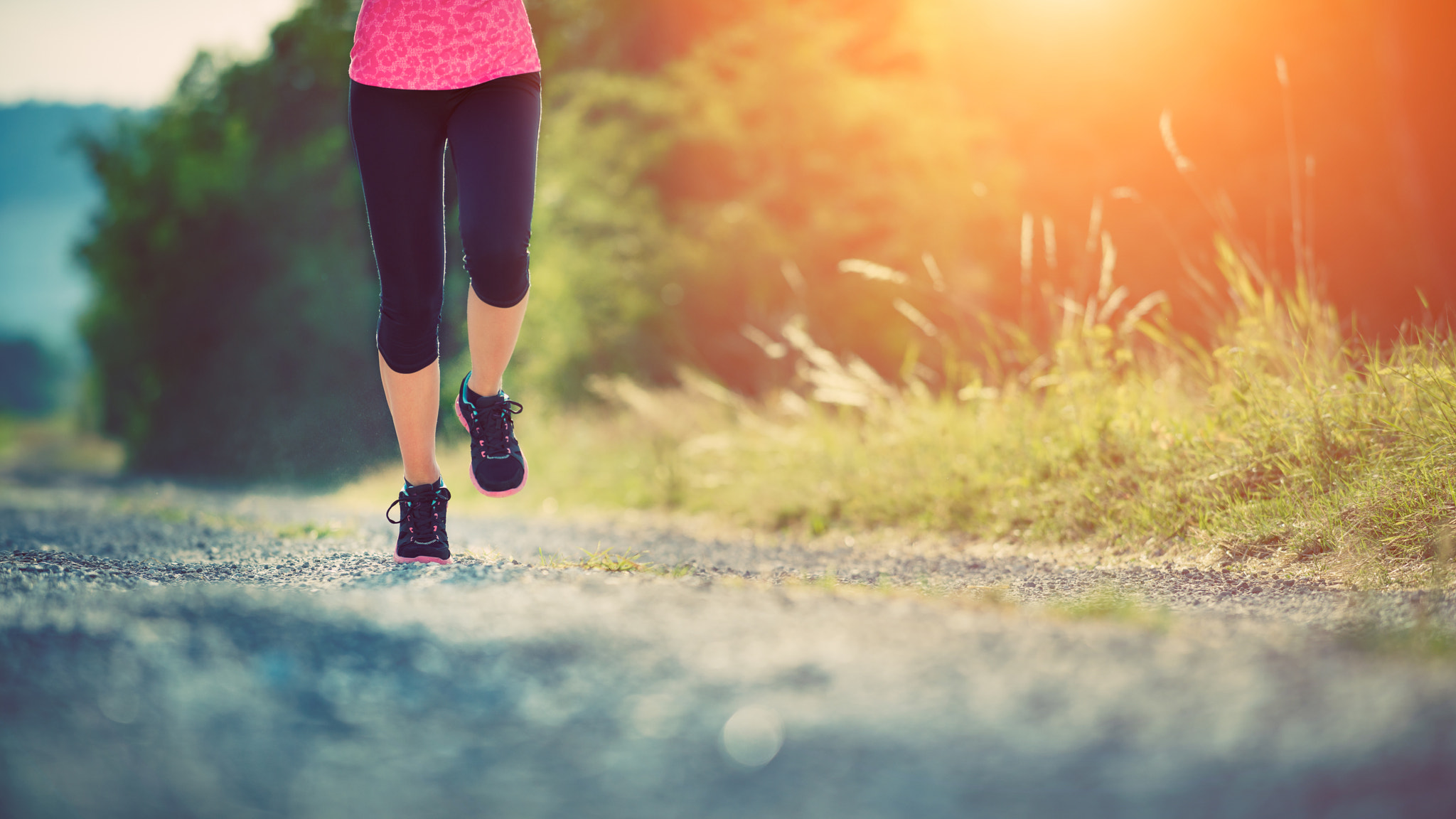 Female athlete runner. closeup on shoe. woman fitness sunset jog workout concept.