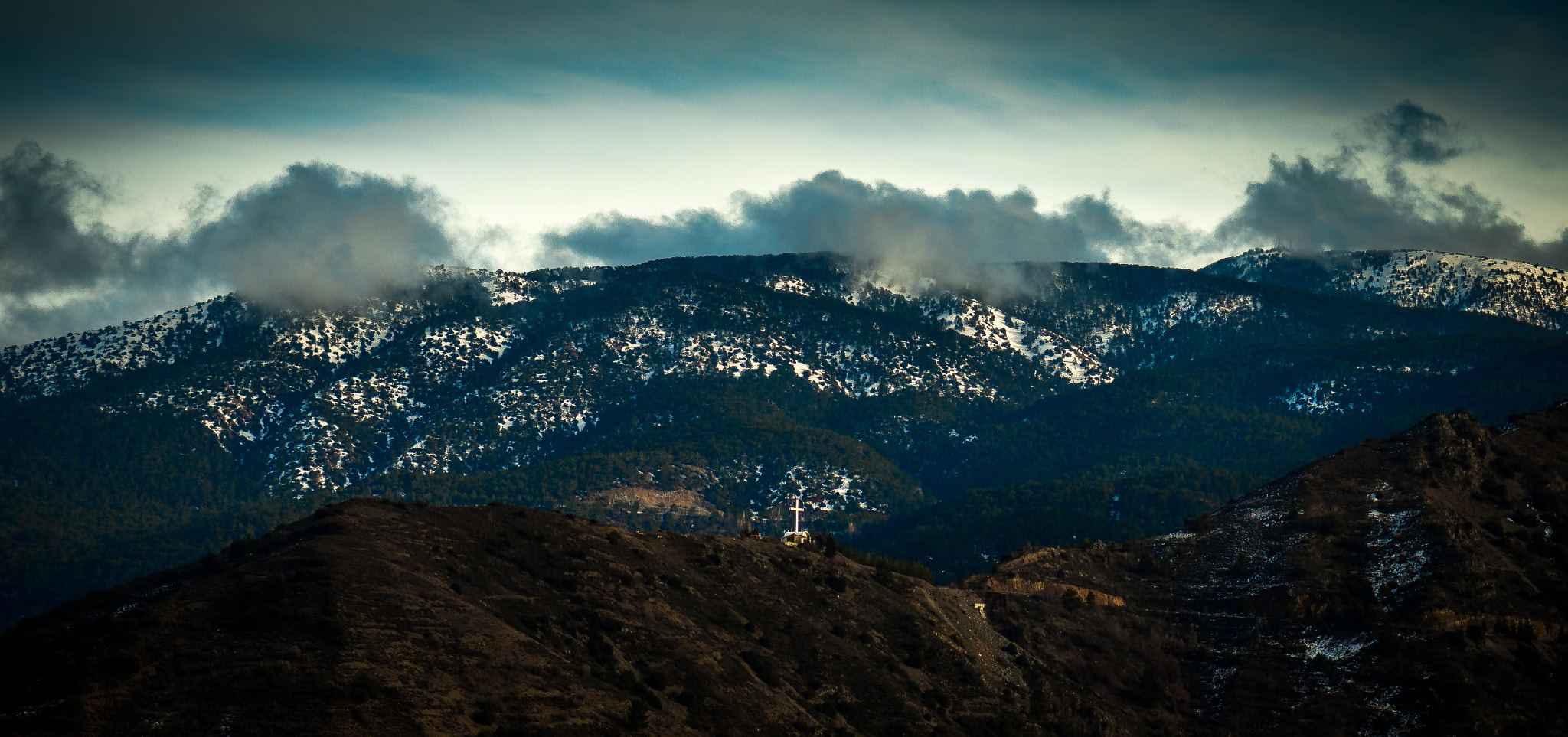 Olympus OM-D E-M10 sample photo. A big christian cross sitting in the mountains photography