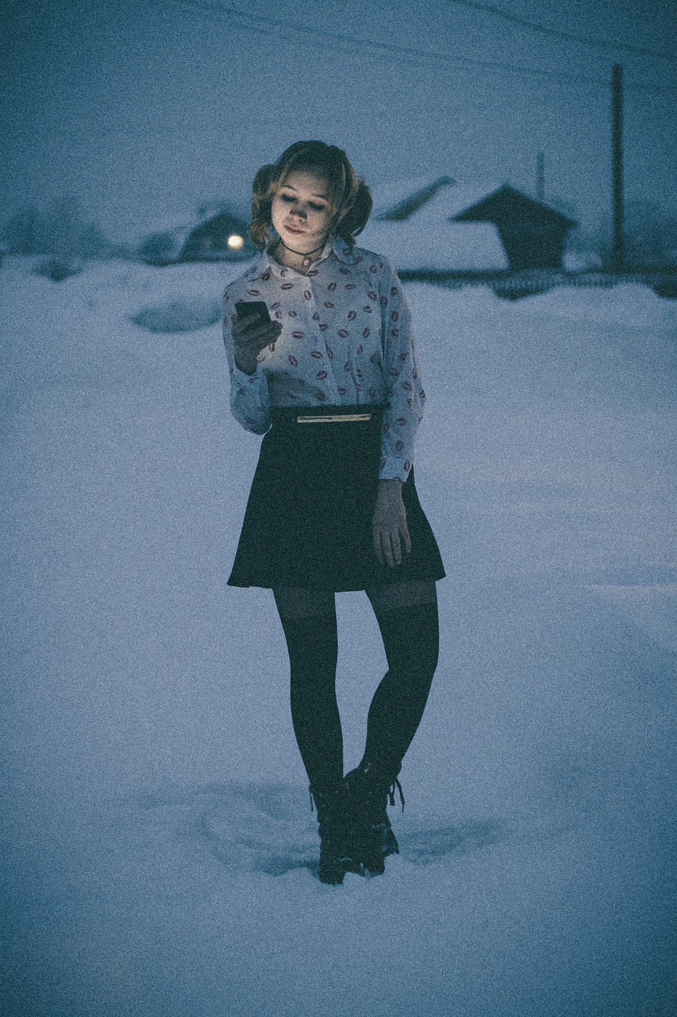 Portrait of a young girl with a phone on the street at night.