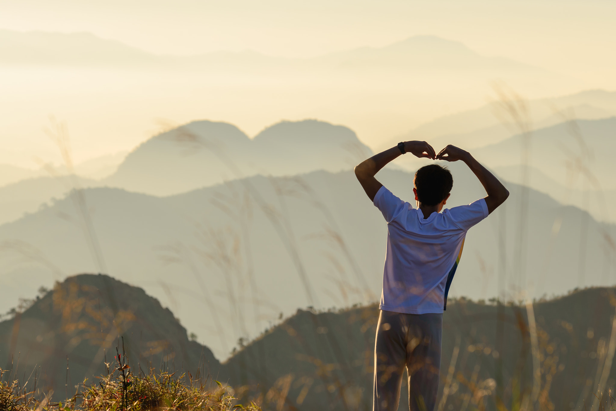 Nikon AF-S Nikkor 70-200mm F4G ED VR sample photo. Backside of man is forming a heart shape at sunset with natural photography
