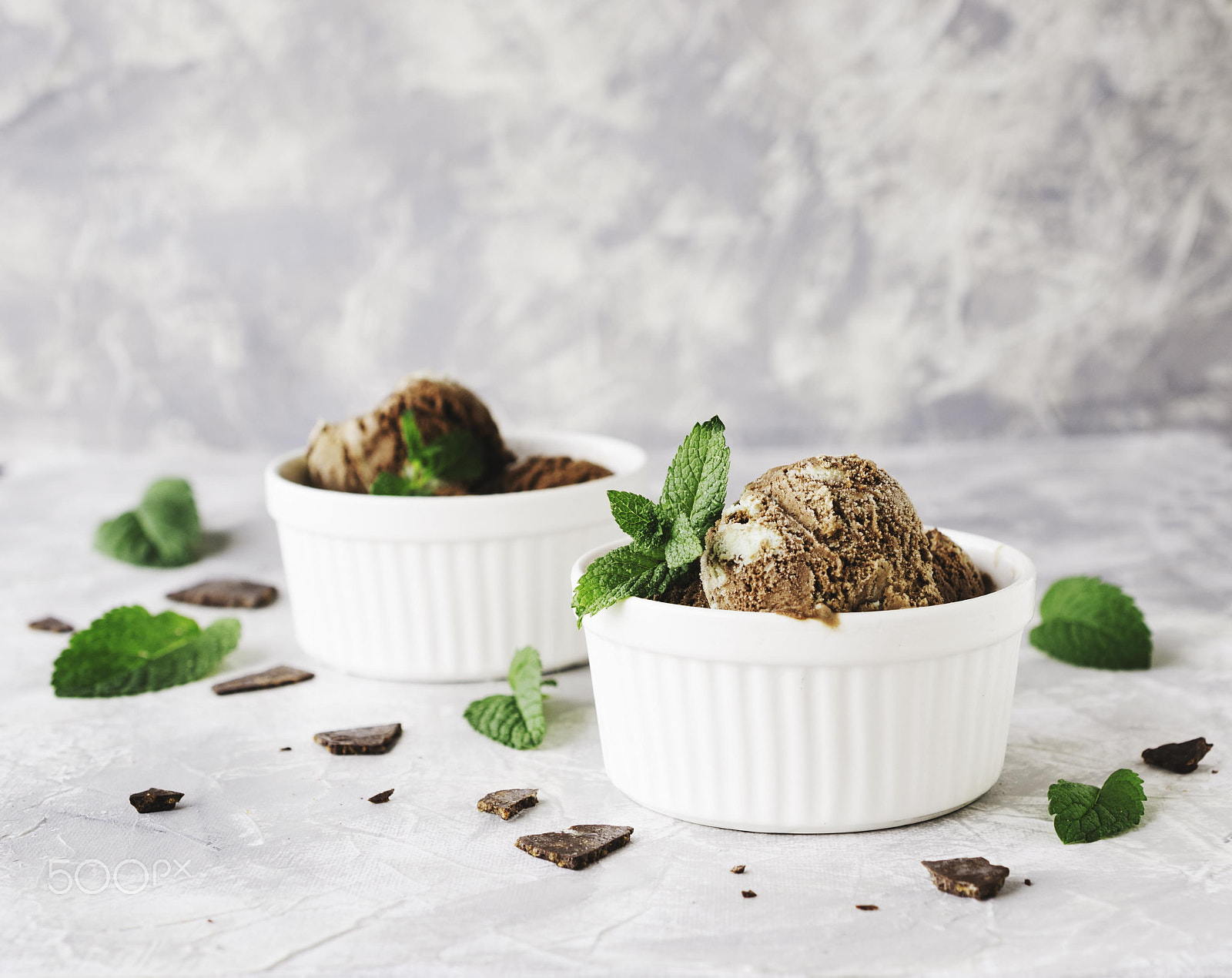 Nikon D7000 + Nikon AF-S DX Micro Nikkor 40mm F2.8 sample photo. Chocolate mint ice cream in white bowls with pieces of chocolate and mint leaves on a marble table photography