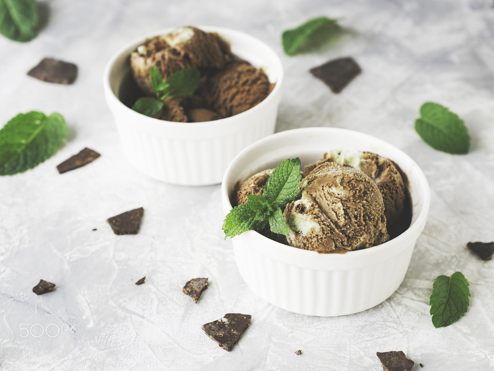 Nikon D7000 + Nikon AF-S DX Micro Nikkor 40mm F2.8 sample photo. Chocolate mint ice cream in white bowls with pieces of chocolate and mint leaves on a marble table photography