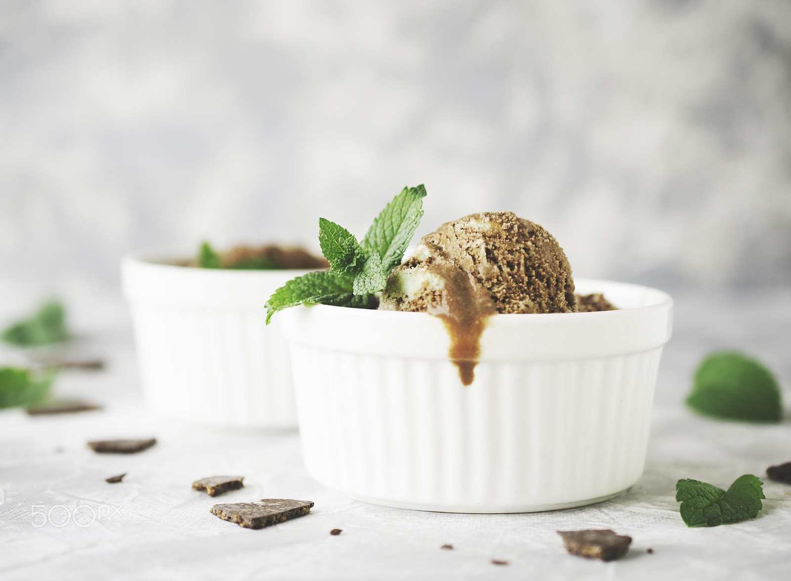 Nikon D7000 + Nikon AF-S DX Micro Nikkor 40mm F2.8 sample photo. Chocolate mint ice cream in white bowls with pieces of chocolate and mint leaves on a marble table photography