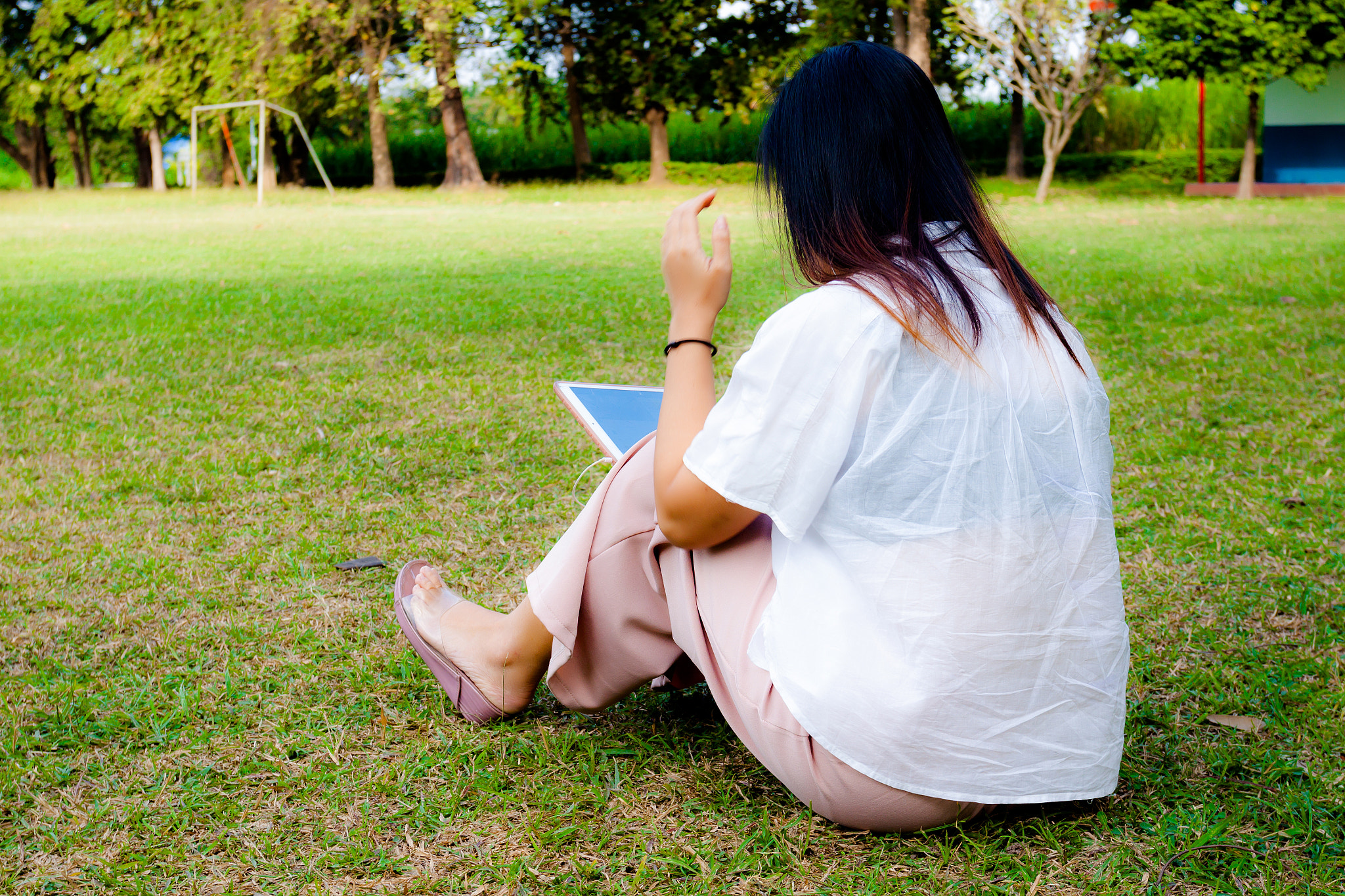 Canon EOS 50D + Canon EF 17-40mm F4L USM sample photo. Young women using table ipad while sitting on grass in the park, photography