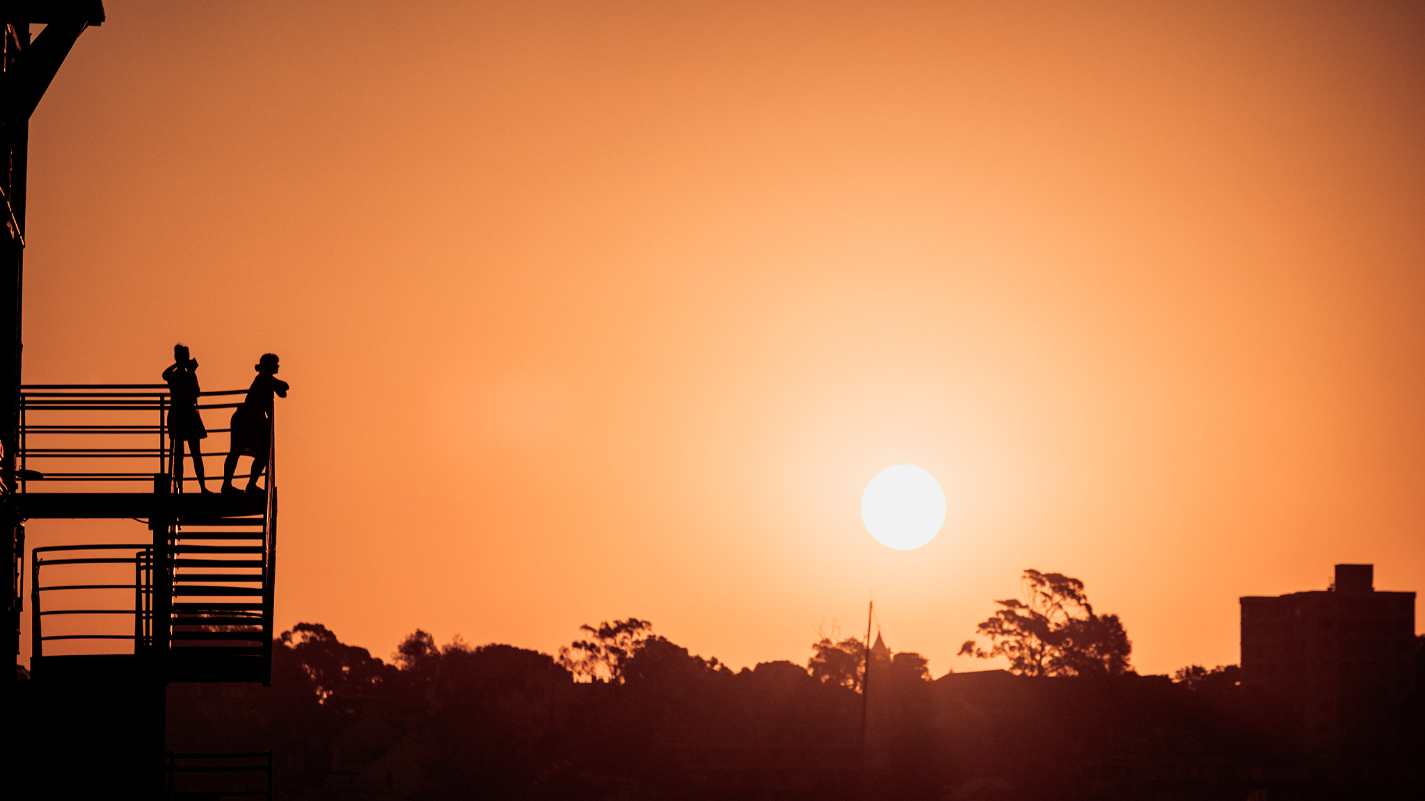 Fujifilm X-T10 + Fujifilm XF 50-140mm F2.8 R LM OIS WR sample photo. Two women watching the sunset from a stair case photography