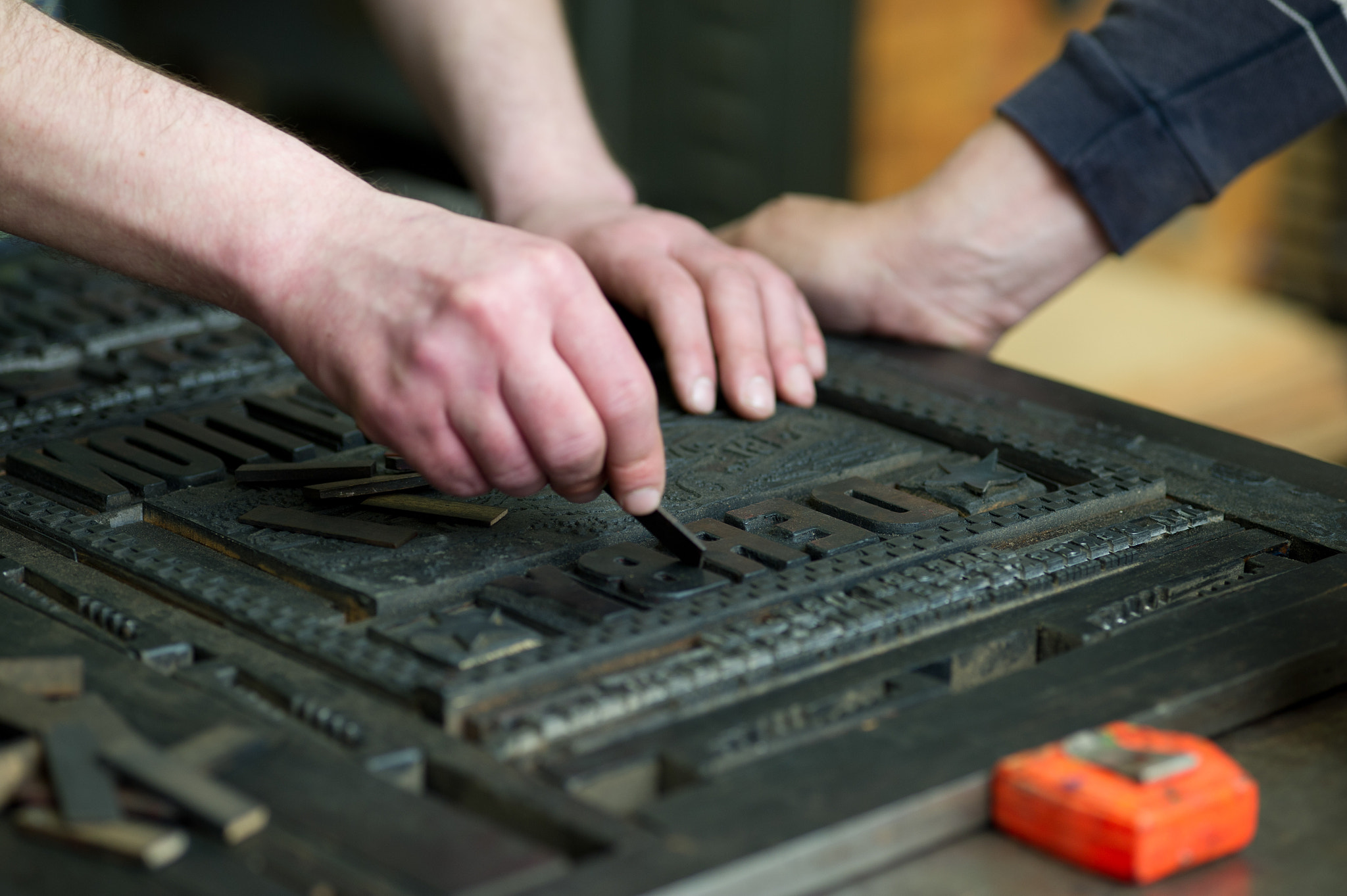 ZEISS Makro-Planar T* 100mm F2 sample photo. Hands working with print block letters photography