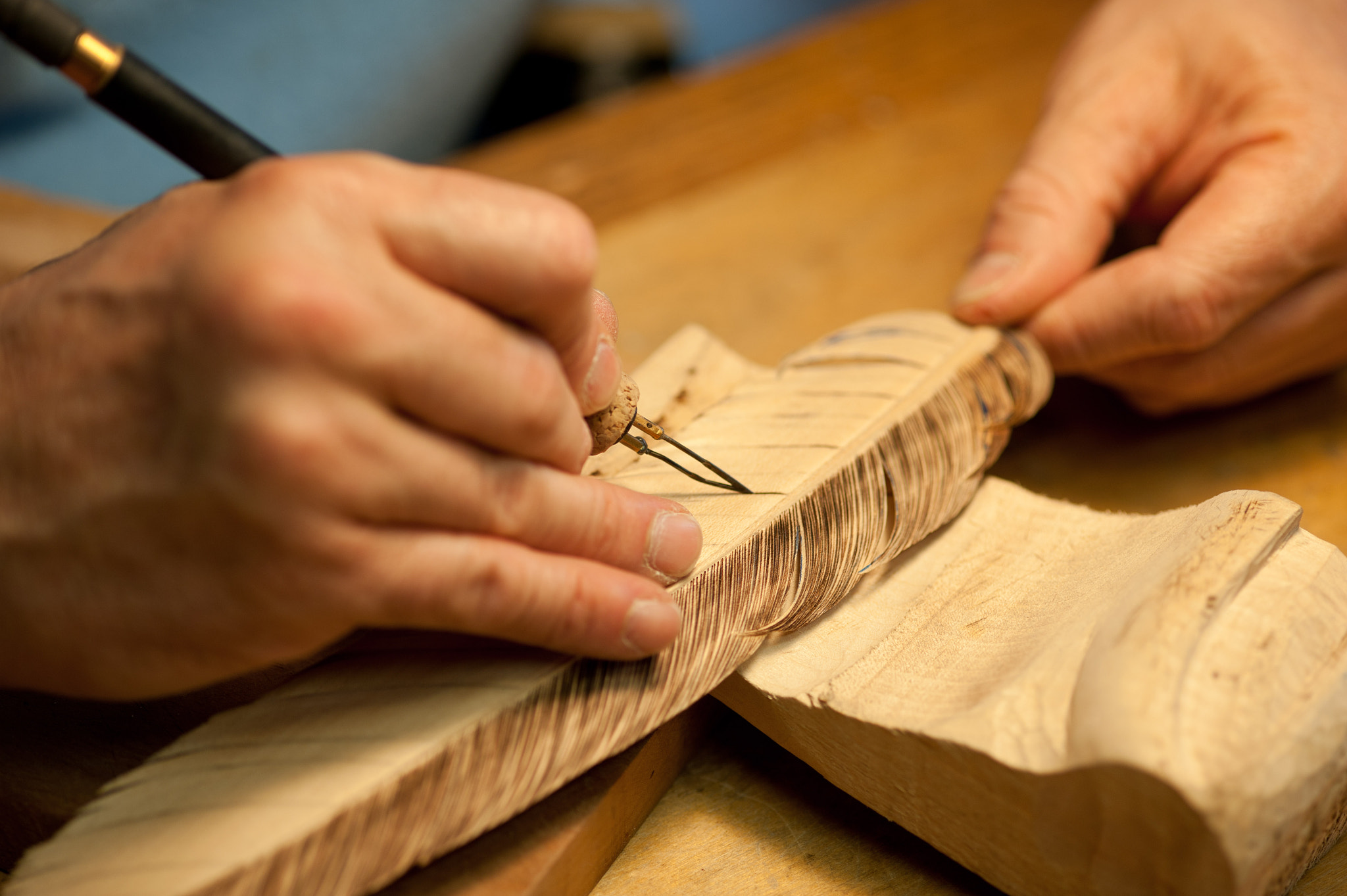 ZEISS Makro-Planar T* 100mm F2 sample photo. Hands carving a bird feather from wood photography