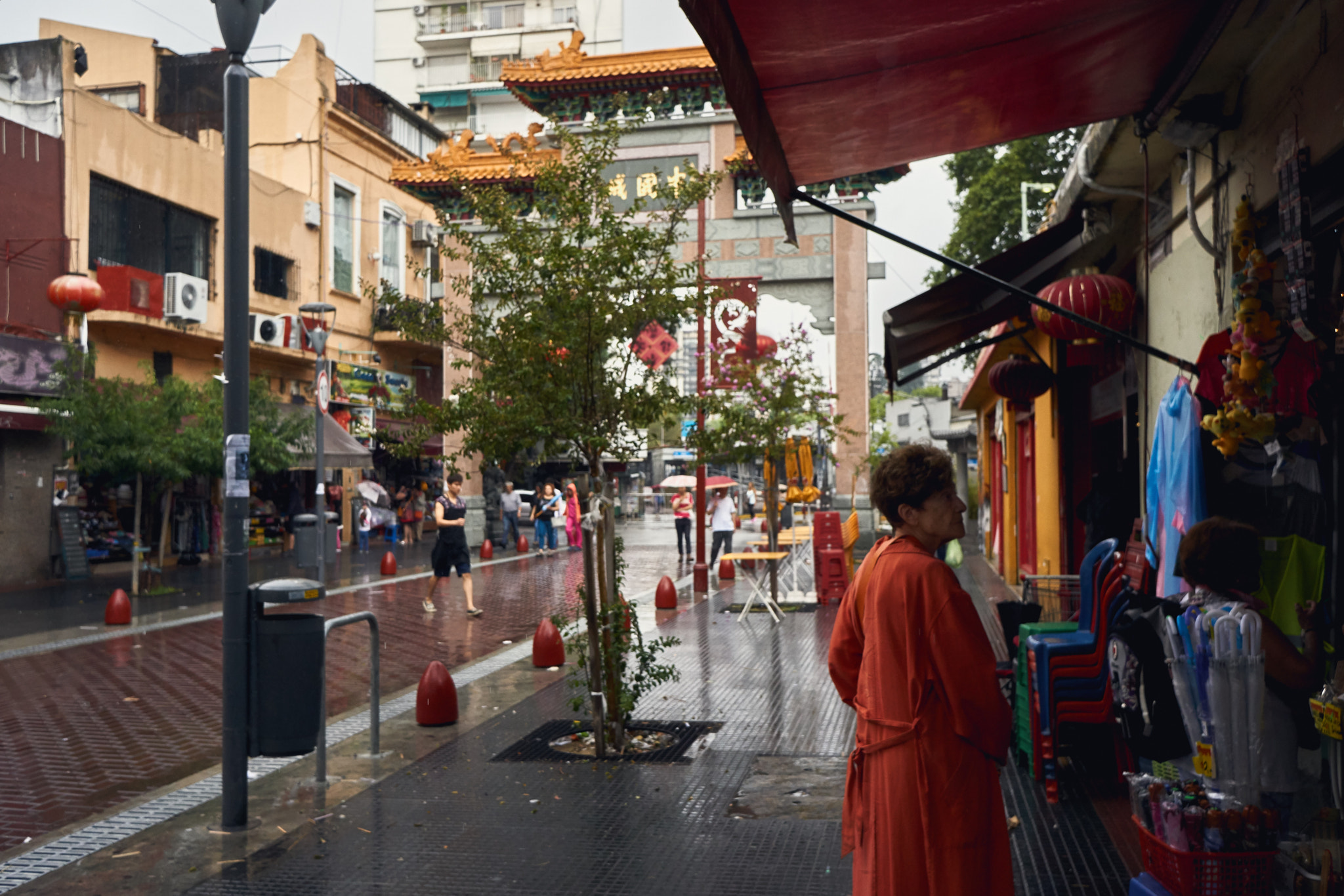 Sony E 20mm F2.8 sample photo. Woman in orange in rainy chinatown photography