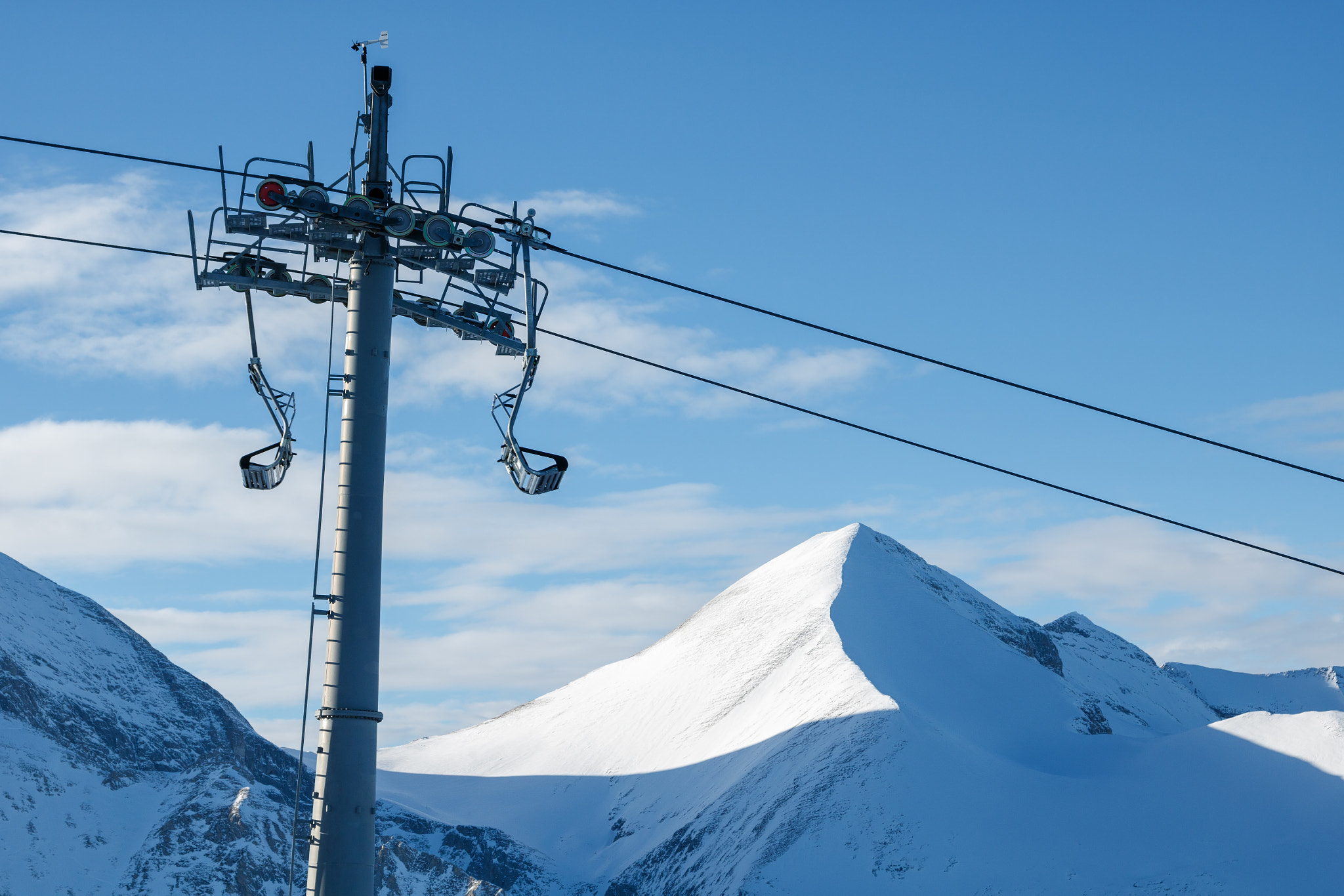 Canon EOS 760D (EOS Rebel T6s / EOS 8000D) + Canon EF 24-105mm F4L IS USM sample photo. Chair lift on a background of mountains and sky photography