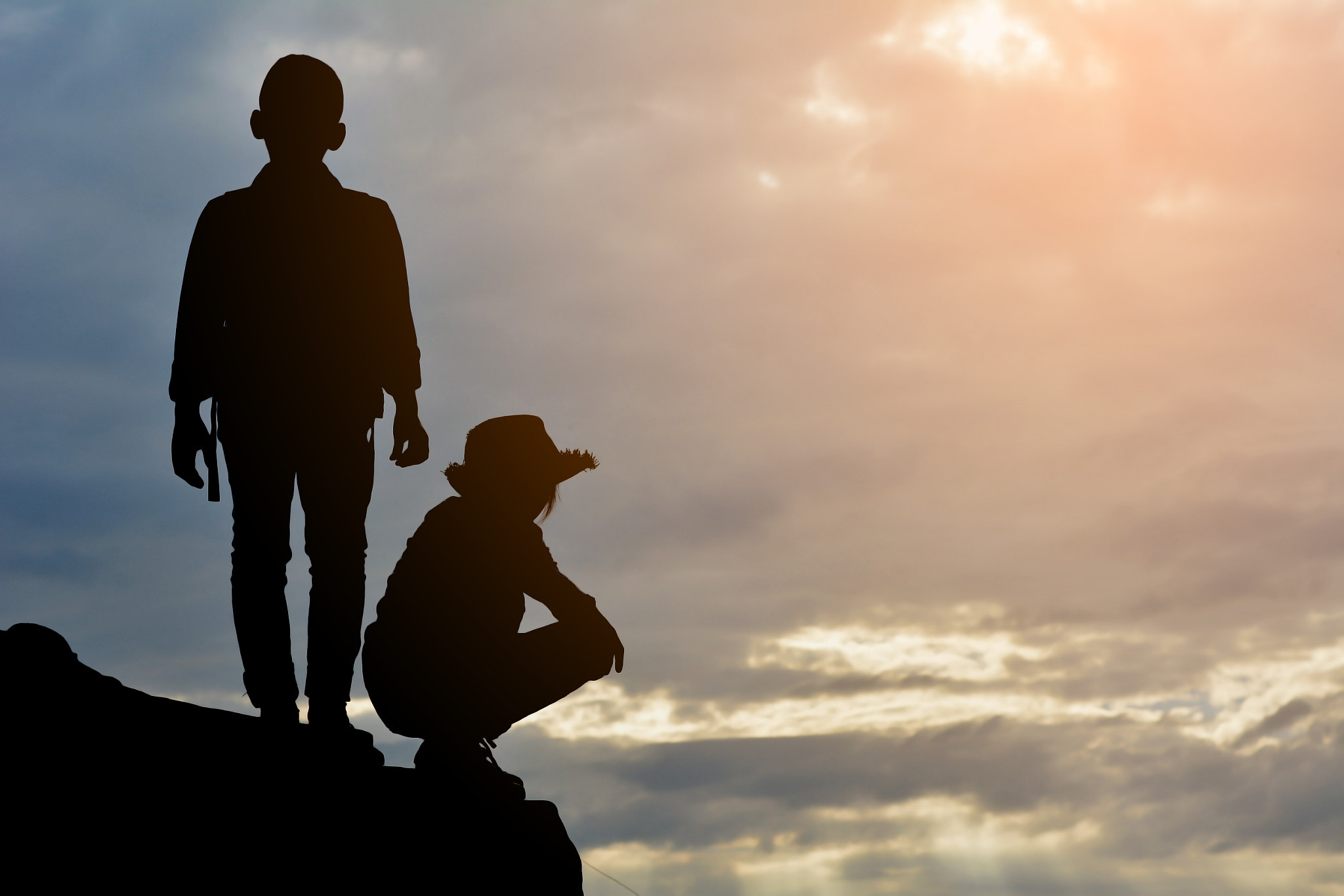 Nikon D5200 + Nikon AF-S Nikkor 50mm F1.4G sample photo. Silhouette of girl and boy on rock at the sky sunset photography