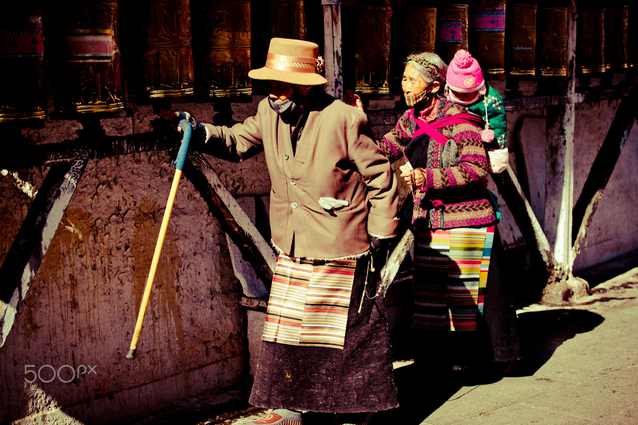 Nikon D810 sample photo. Grandparents with grandkid turning the prayer wheels at barkhor, lhasa, tibet. photography