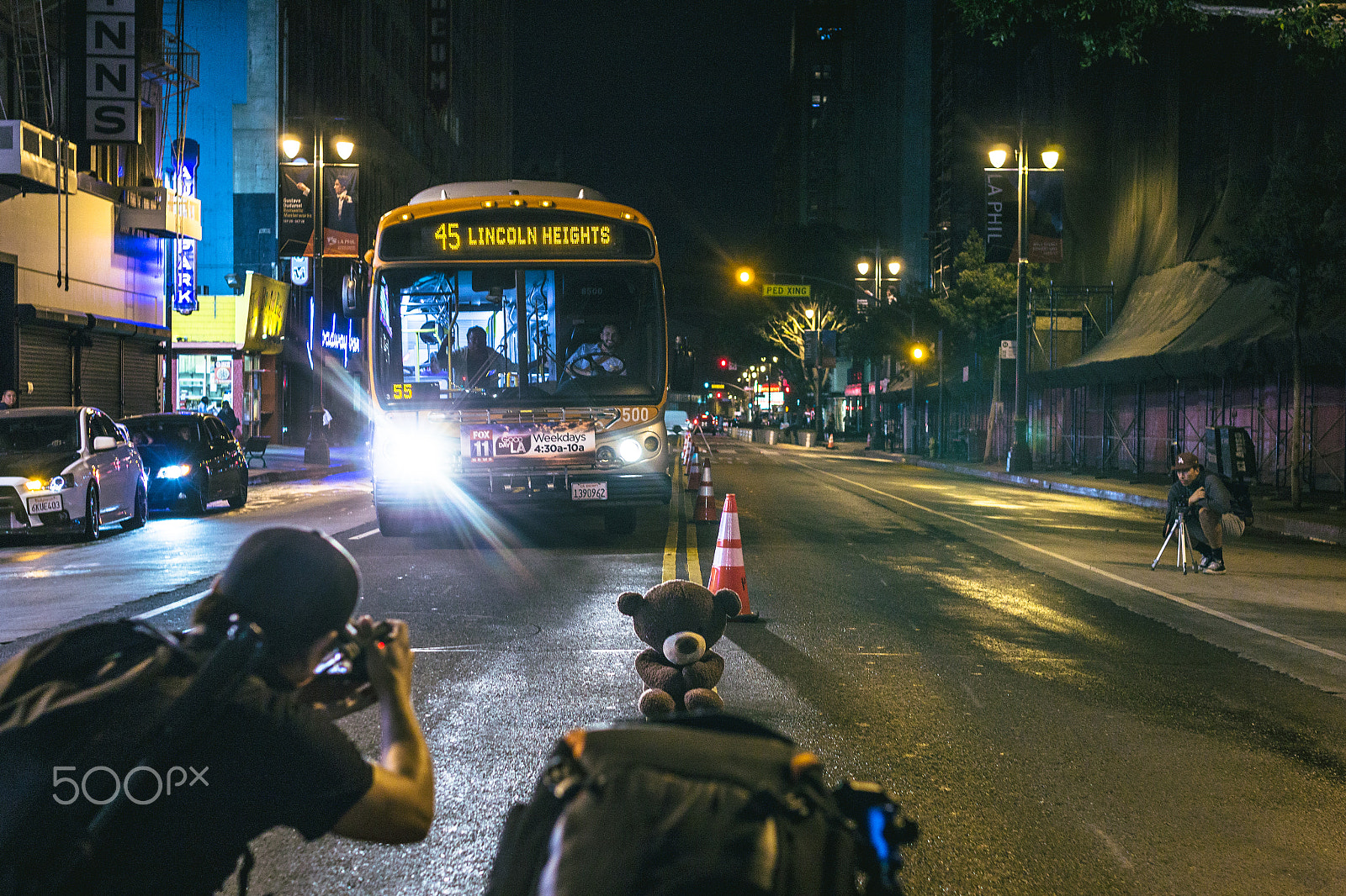 Sigma 30mm F1.4 EX DC HSM sample photo. Photographers taking pictures of a bear in the middle of the street while bus drives by photography