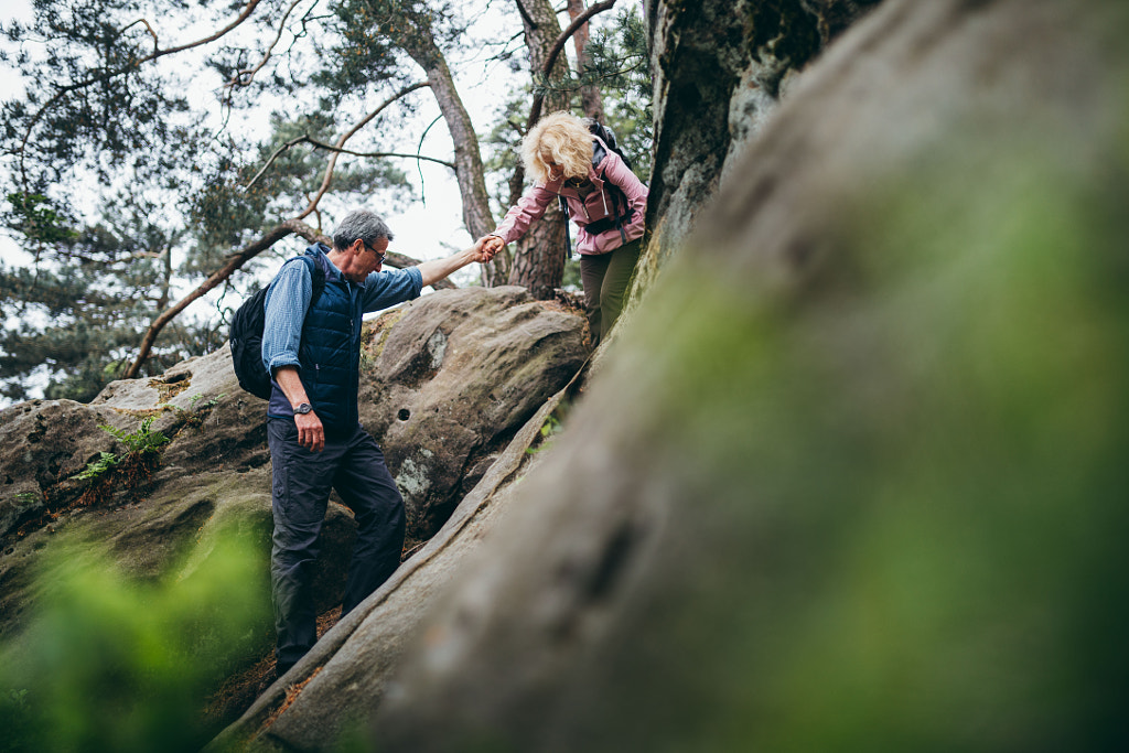 Caucasian Senior couple hiking on rocks in forest by Carina König on 500px.com