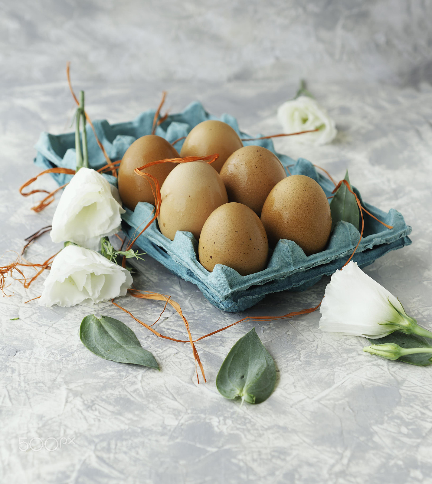 Nikon D7000 sample photo. Raw eggs in a carton for eggs with white flowers on a marble white table, ready for painting... photography