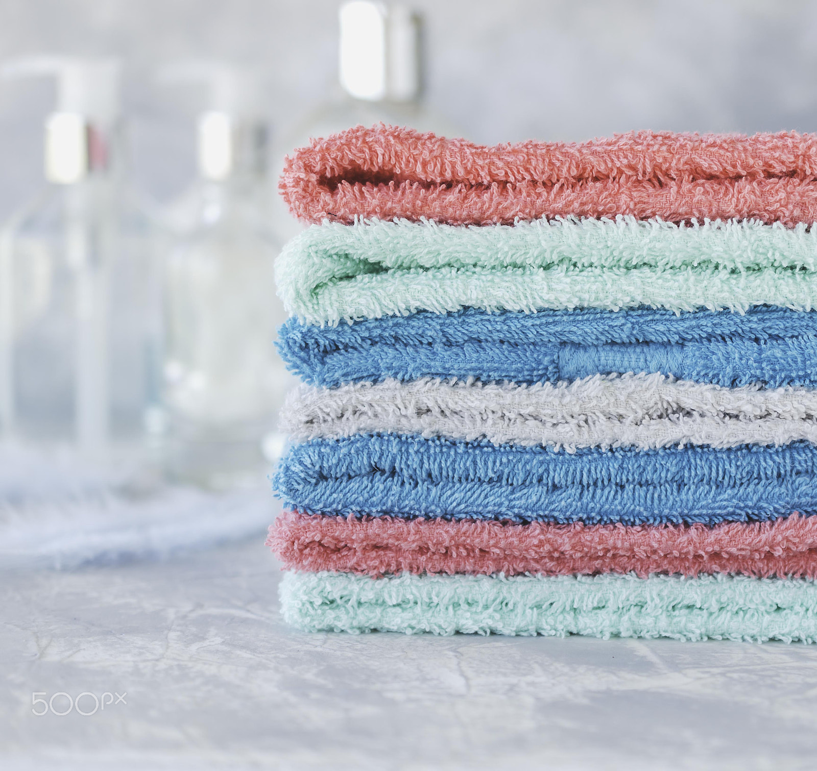 Nikon AF-S DX Micro Nikkor 40mm F2.8 sample photo. Stack of towels for bathroom bottles on a white marble background, space for text, selective focus photography