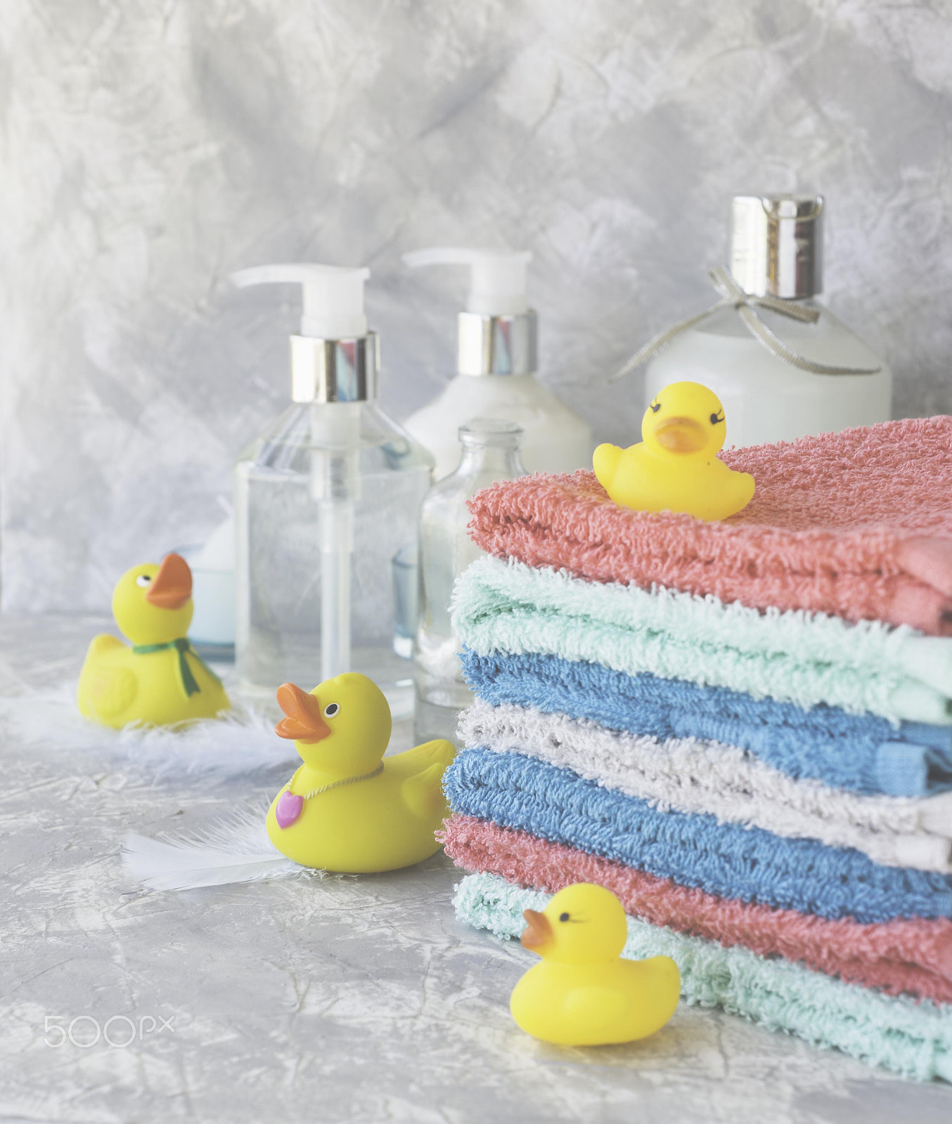 Nikon D7000 sample photo. Stack of towels with yellow rubber bath ducks on white marble background, space for text,... photography