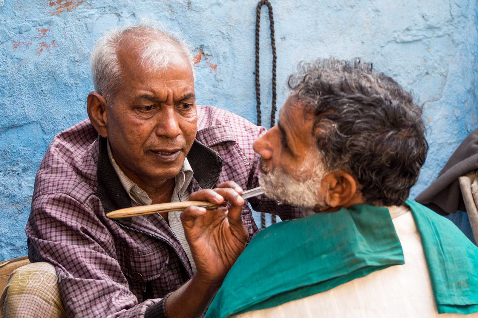 Olympus OM-D E-M5 sample photo. A barber who makes nice beard for him in street photography