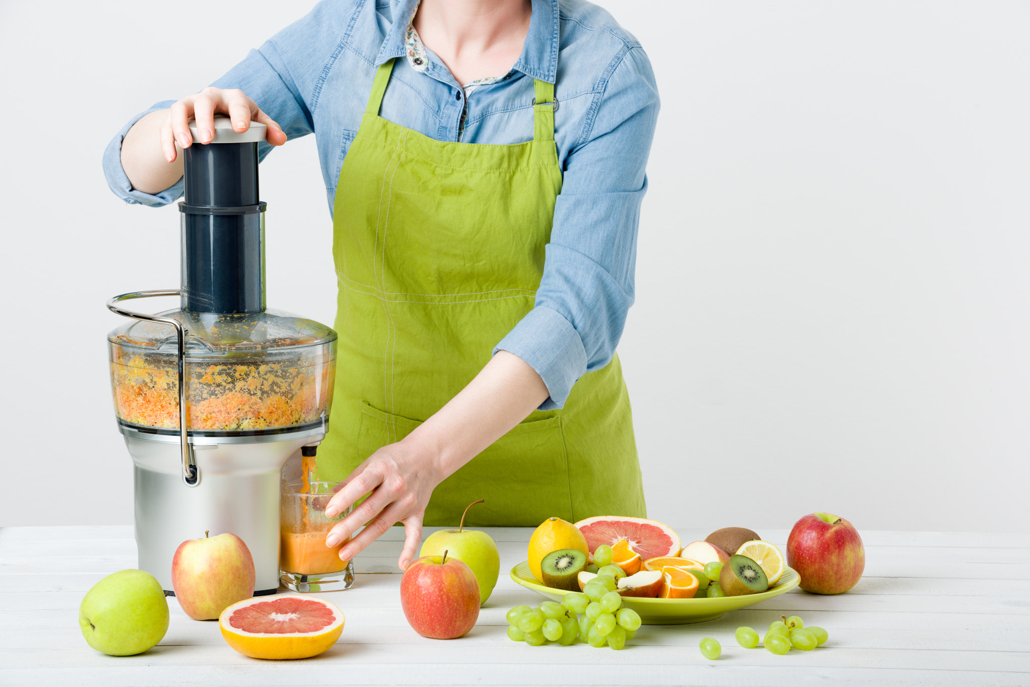 Nikon D810 sample photo. Anonymous woman wearing an apron, preparing healthy fruit juice using modern electric juicer,... photography