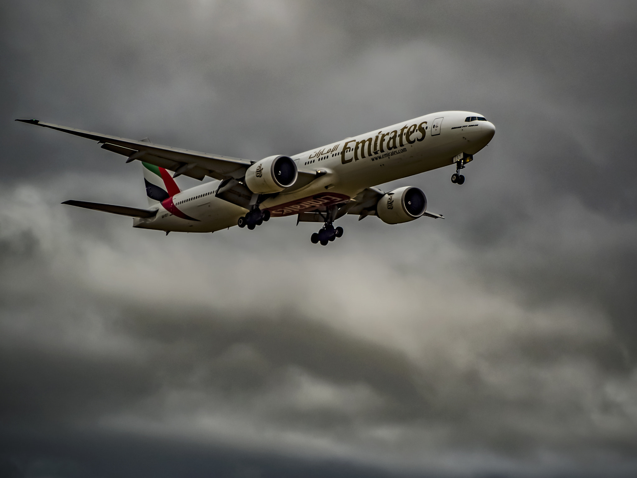 Olympus PEN-F + Panasonic Lumix G Vario 45-200mm F4-5.6 OIS sample photo. Emirates 777 on final approach photography