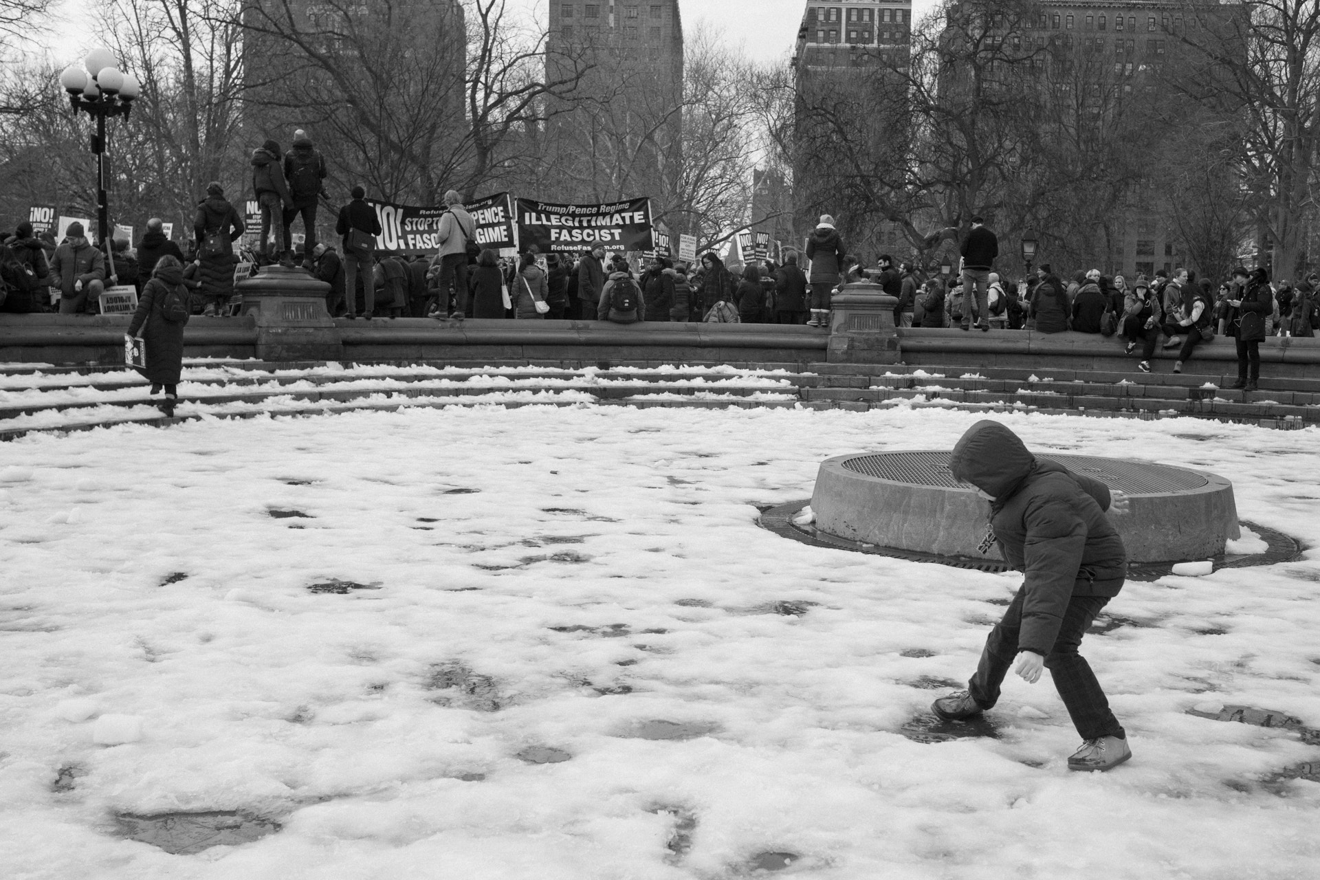 Sony a7 II + Canon EF 35mm F2 IS USM sample photo. A child plays while a crowd protests photography