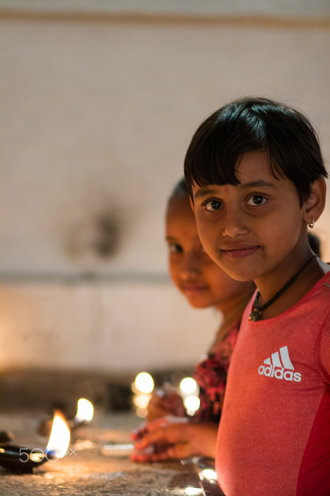 Canon EOS 80D + Canon EF 85mm F1.8 USM sample photo. A girl lighting a diya photography