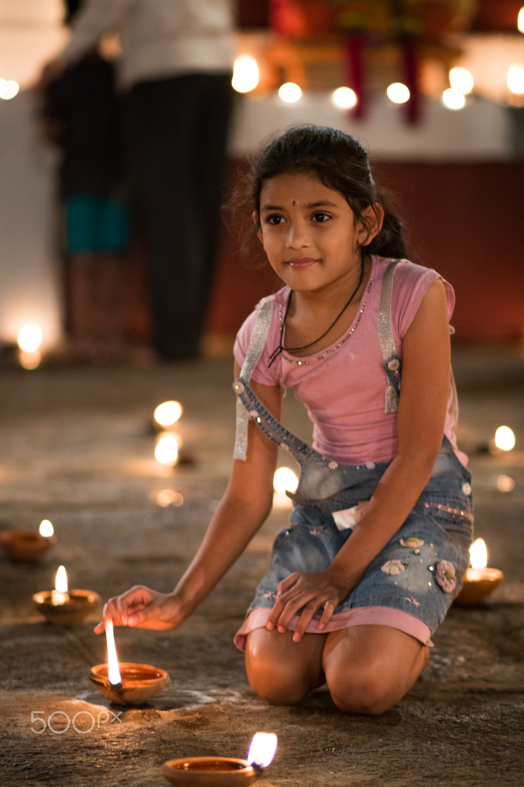 Canon EOS 80D + Canon EF 85mm F1.8 USM sample photo. A girl lighting a diya photography