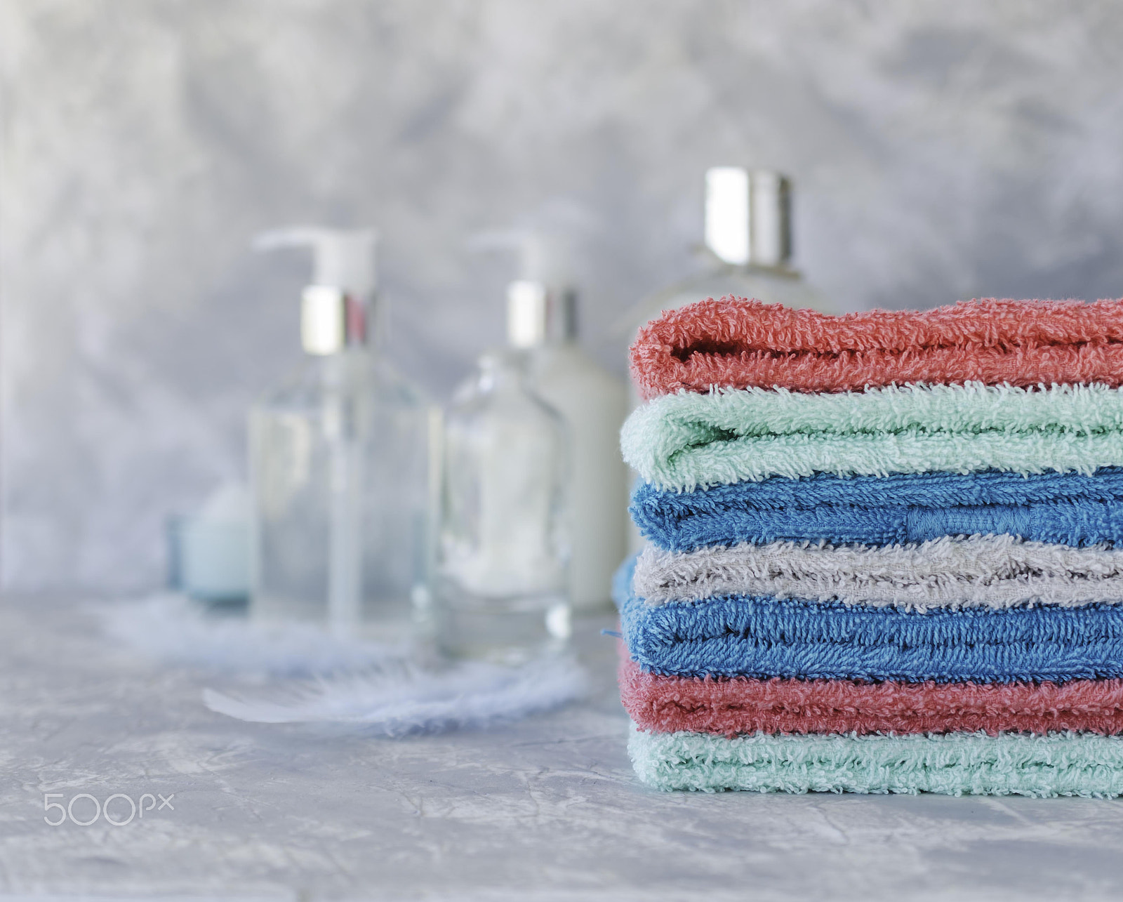 Nikon D7000 + Nikon AF-S DX Micro Nikkor 40mm F2.8 sample photo. Stack of towels for bathroom bottles on a white marble background, space for text, selective focus photography