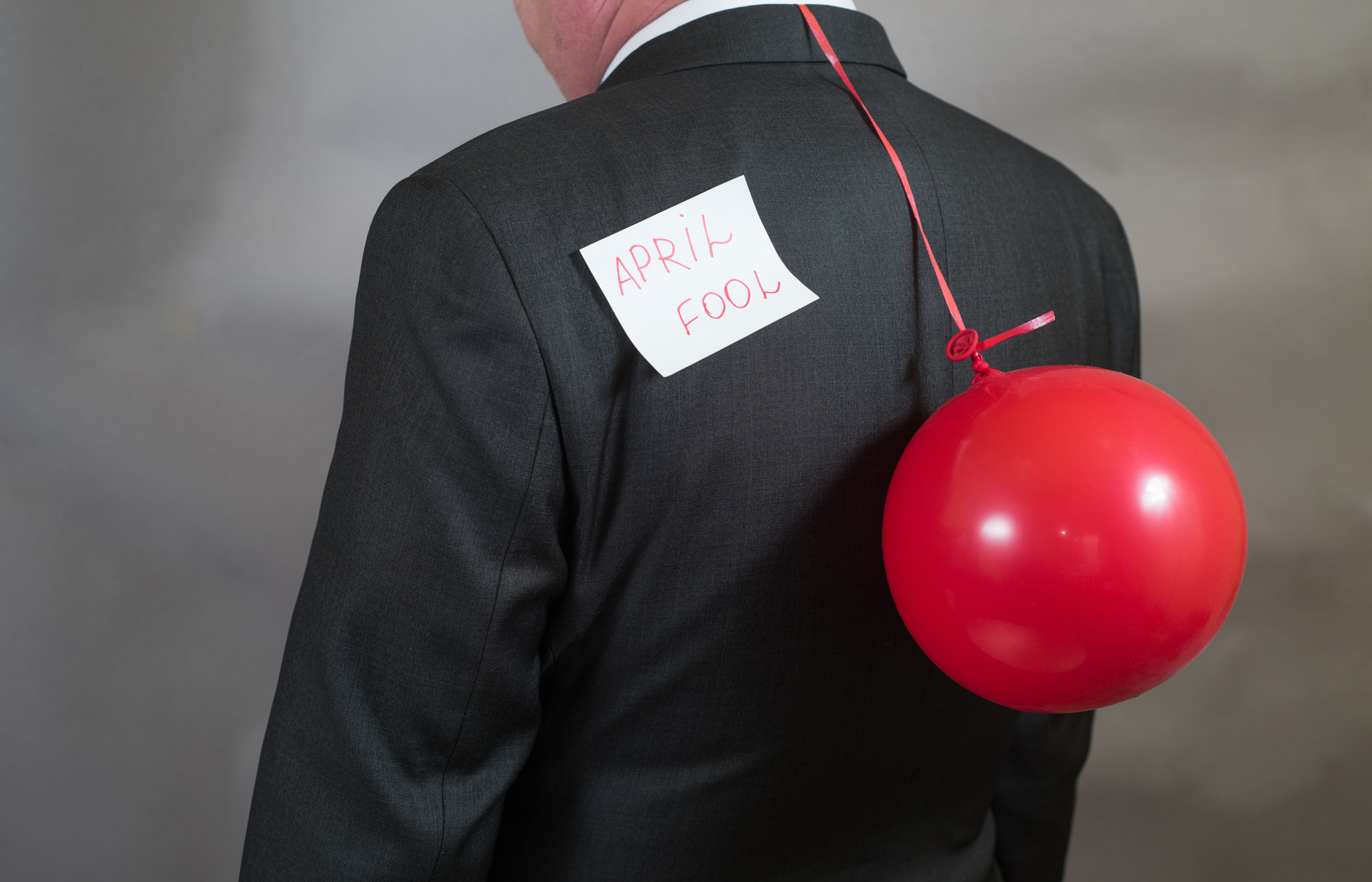 Nikon D810 + Nikon AF Nikkor 50mm F1.8D sample photo. Fool's day is businessman with a balloon behind his back photography