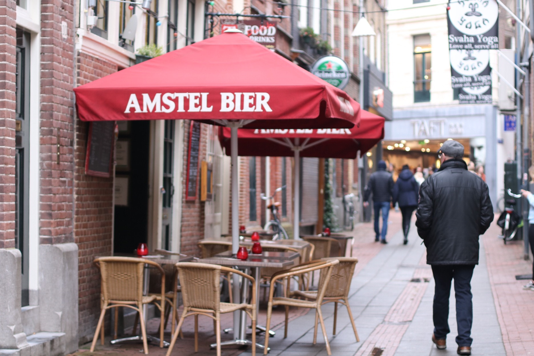 Canon EOS 760D (EOS Rebel T6s / EOS 8000D) + Canon EF 50mm F1.4 USM sample photo. Cafe and a passerby, amsterdam photography