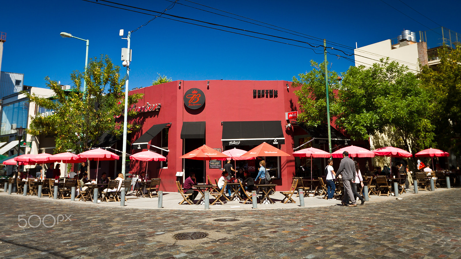 Canon EF 16-35mm F2.8L II USM sample photo. Colorful red building with a street cafe photography