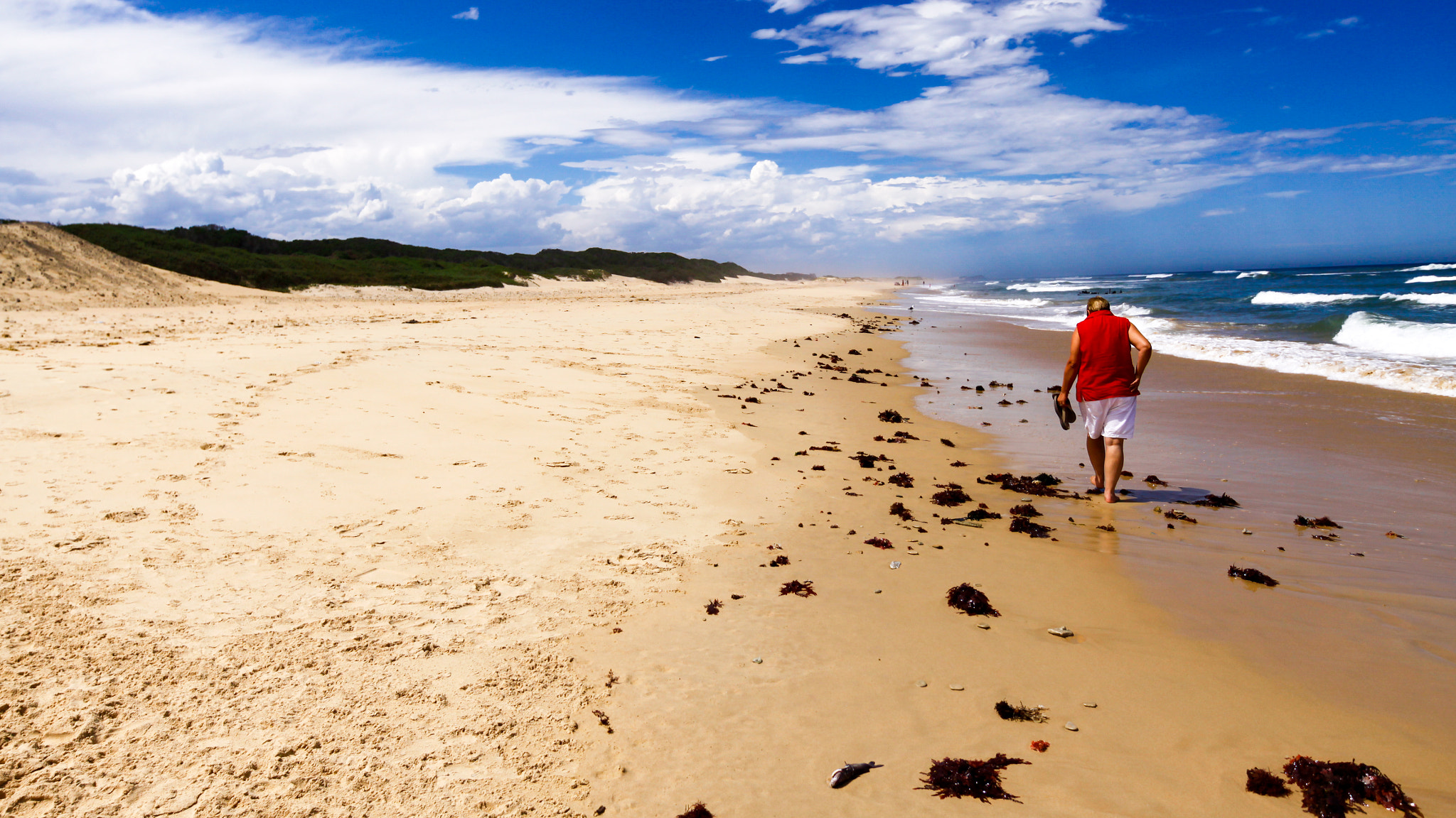 Canon EF 300mm f/2.8L sample photo. Lady walking on the sand on a cloudy day photography