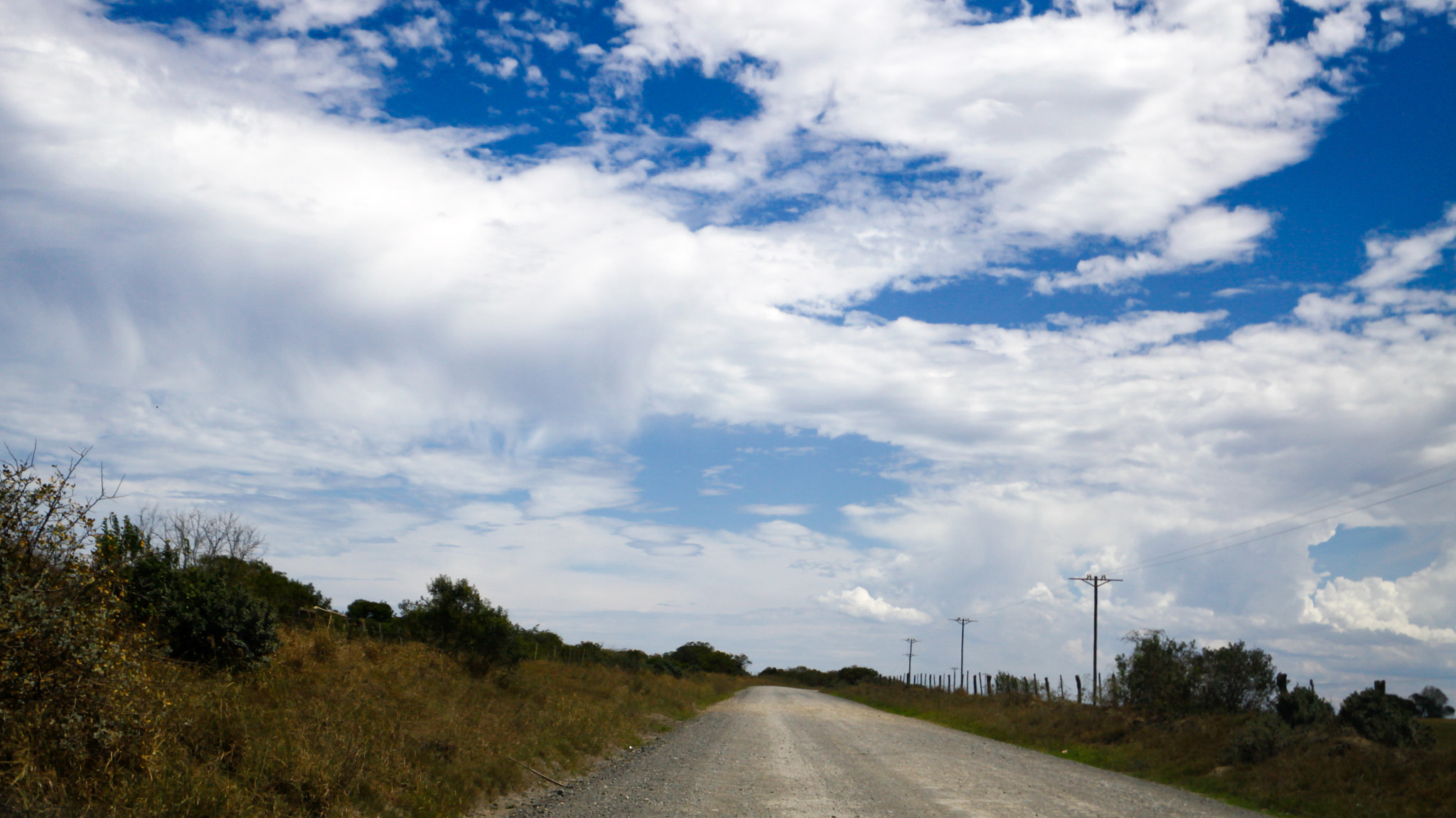 Canon EOS 50D + Canon EF 300mm f/2.8L sample photo. Dusty road with a hole in the clouds photography