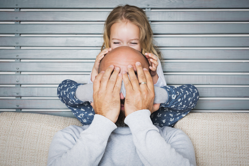 Happy family concept, father and daughter portrait, sitting on a couch having fun by Andrea Obzerova on 500px.com