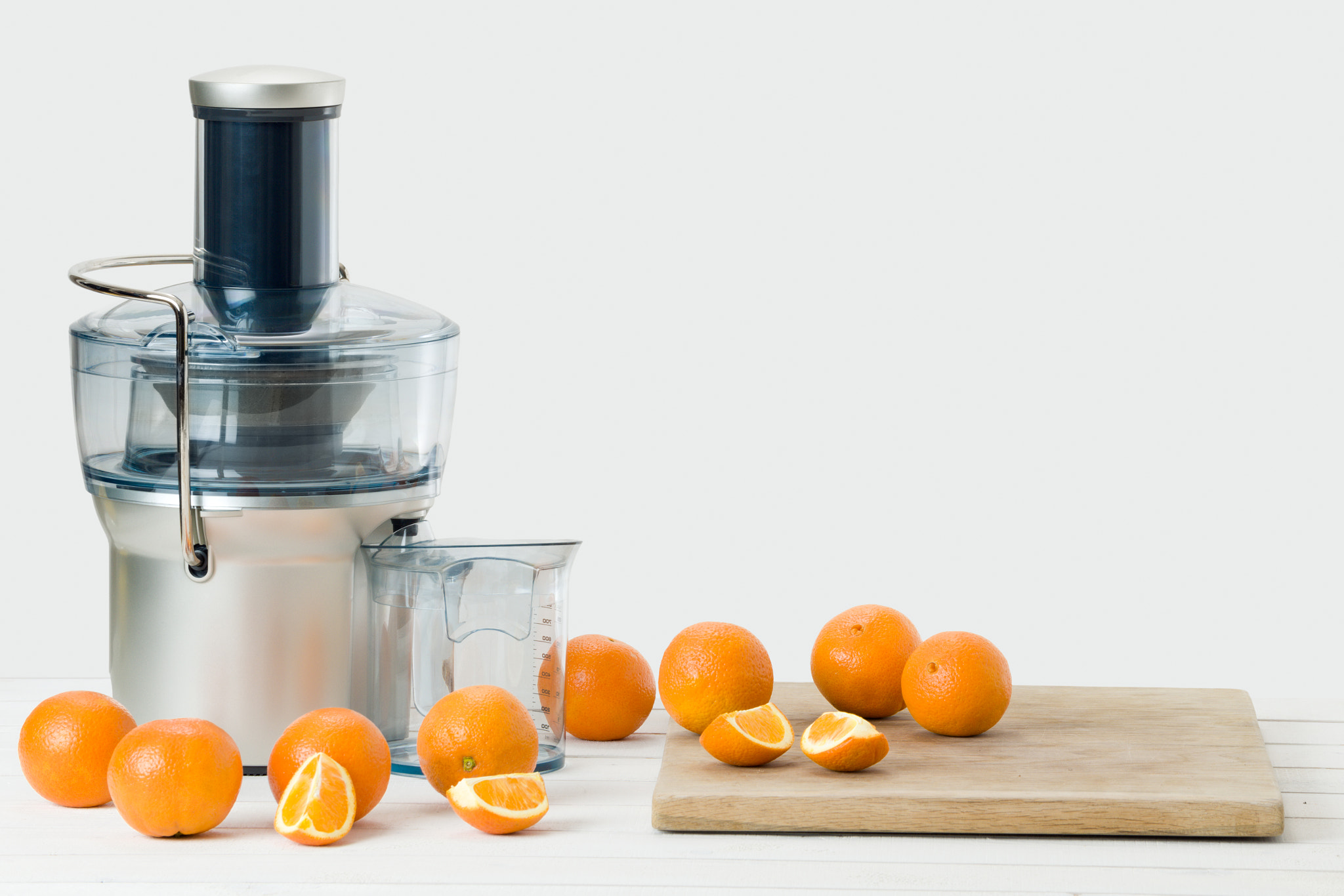 Nikon D810 sample photo. Modern electric juicer and fresh oranges, white background with copy space photography