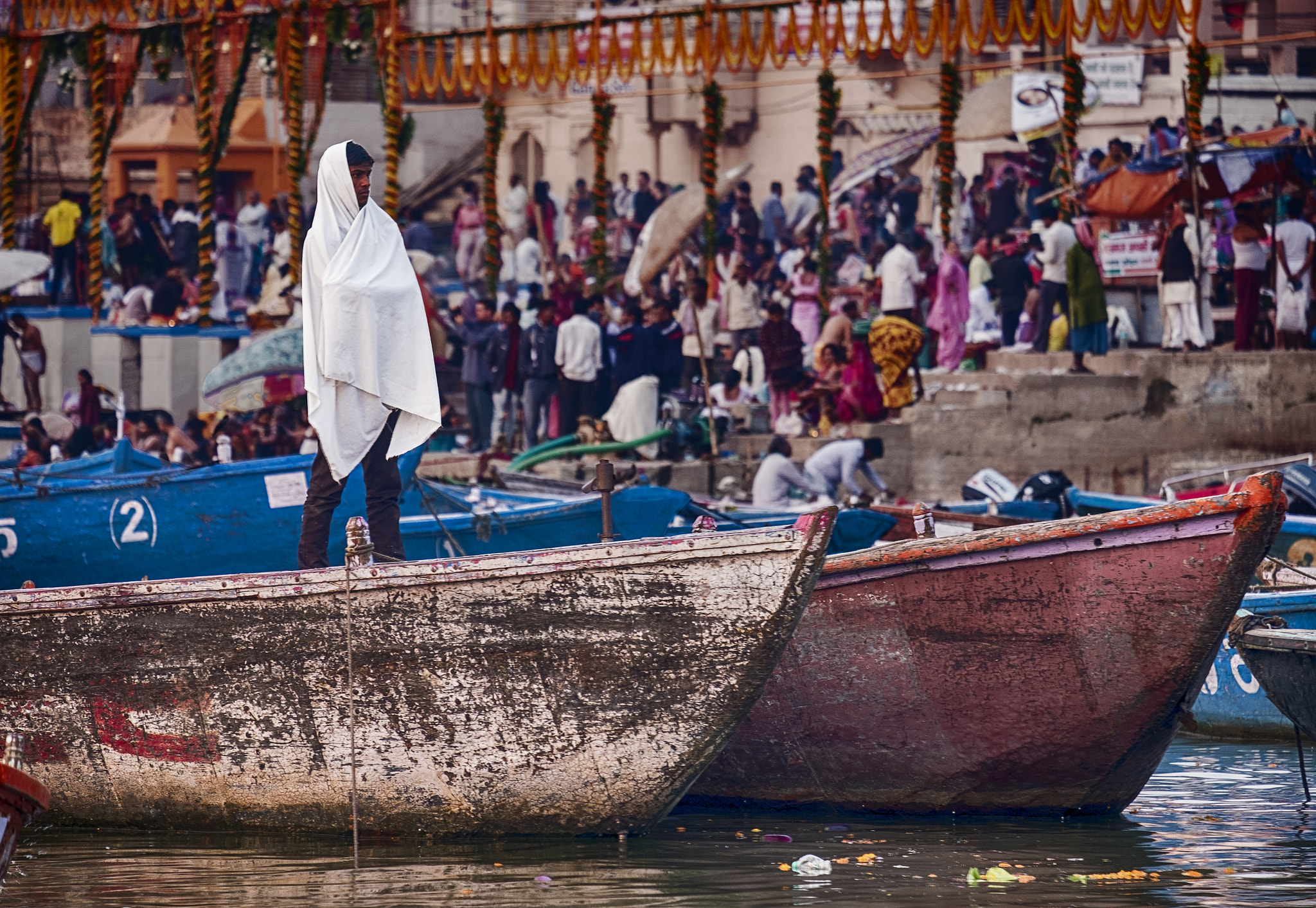 Fujifilm X-Pro2 + Fujifilm XF 55-200mm F3.5-4.8 R LM OIS sample photo. Man on boat near a varanasi ghat photography