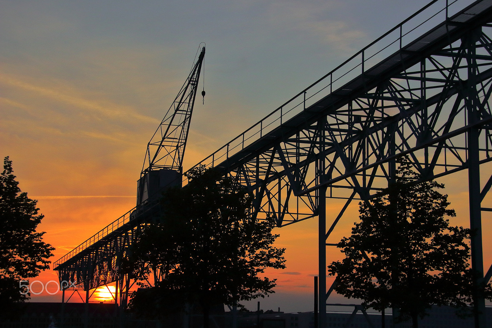 Sigma 18-200mm f/3.5-6.3 DC OS sample photo. Sunset behind crane photography