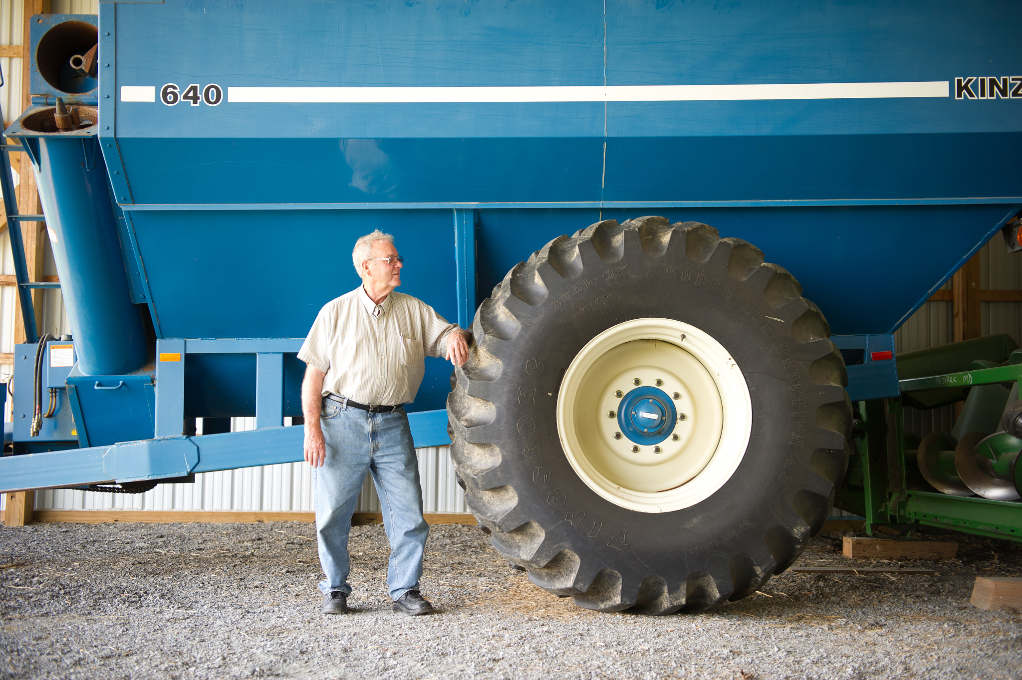 Nikon D3S sample photo. Farmer standing next to machinery for grain production photography