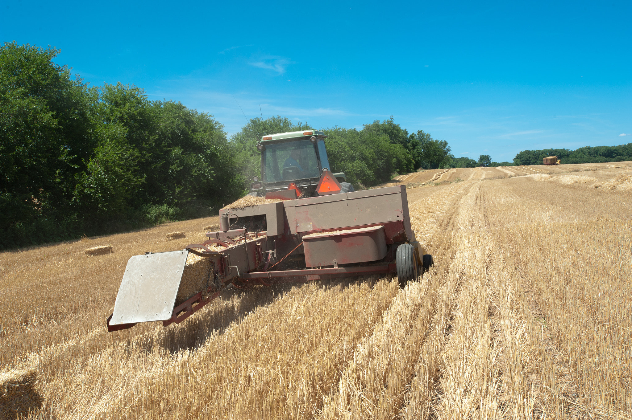 Nikon D700 + Nikon AF-S Nikkor 17-35mm F2.8D ED-IF sample photo. Hay baler working in field photography