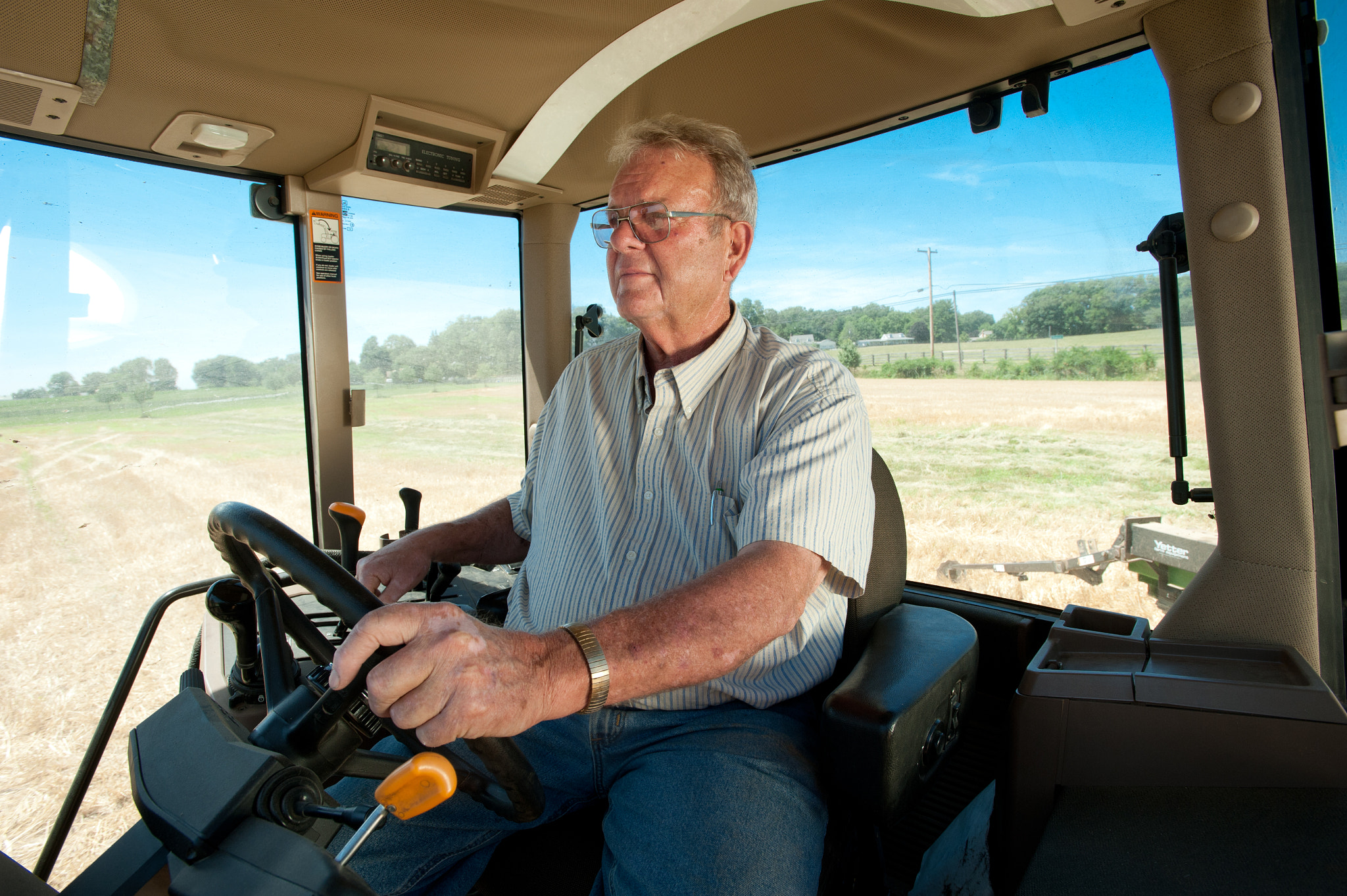 Nikon AF-S Nikkor 17-35mm F2.8D ED-IF sample photo. Farmer operating combine for harvesting grain photography