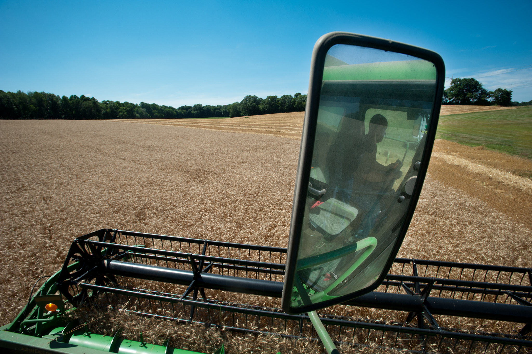 Nikon AF-S Nikkor 17-35mm F2.8D ED-IF sample photo. Farmer operating combine harvesting grain photography