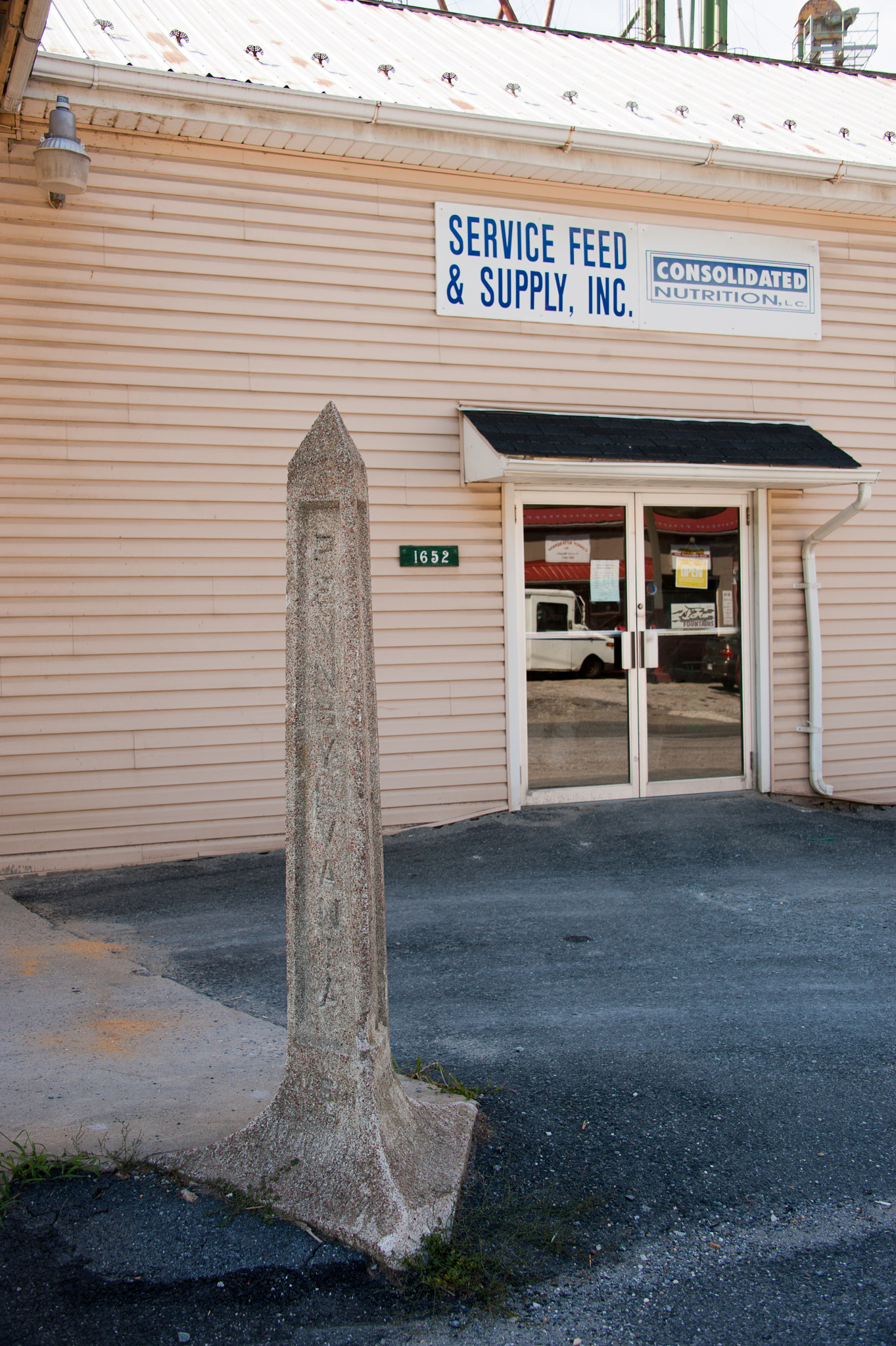 Nikon D700 sample photo. Mason dixon line marker in front of a feed store photography
