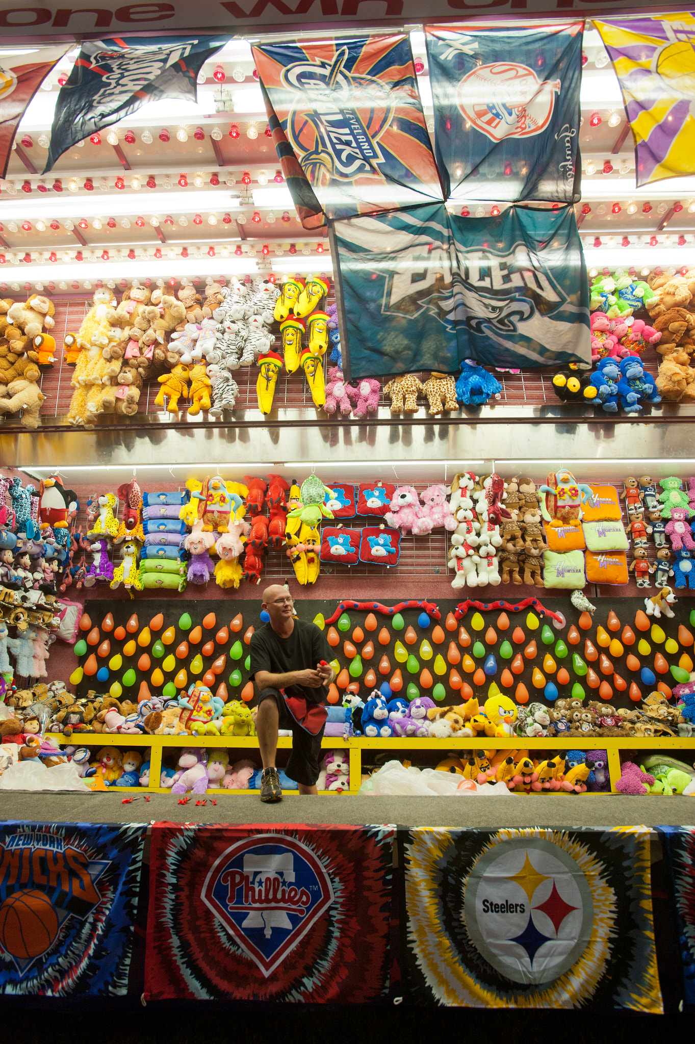 Nikon AF-S Nikkor 17-35mm F2.8D ED-IF sample photo. Man working the stand for games and prizes at the mason dixon fair photography