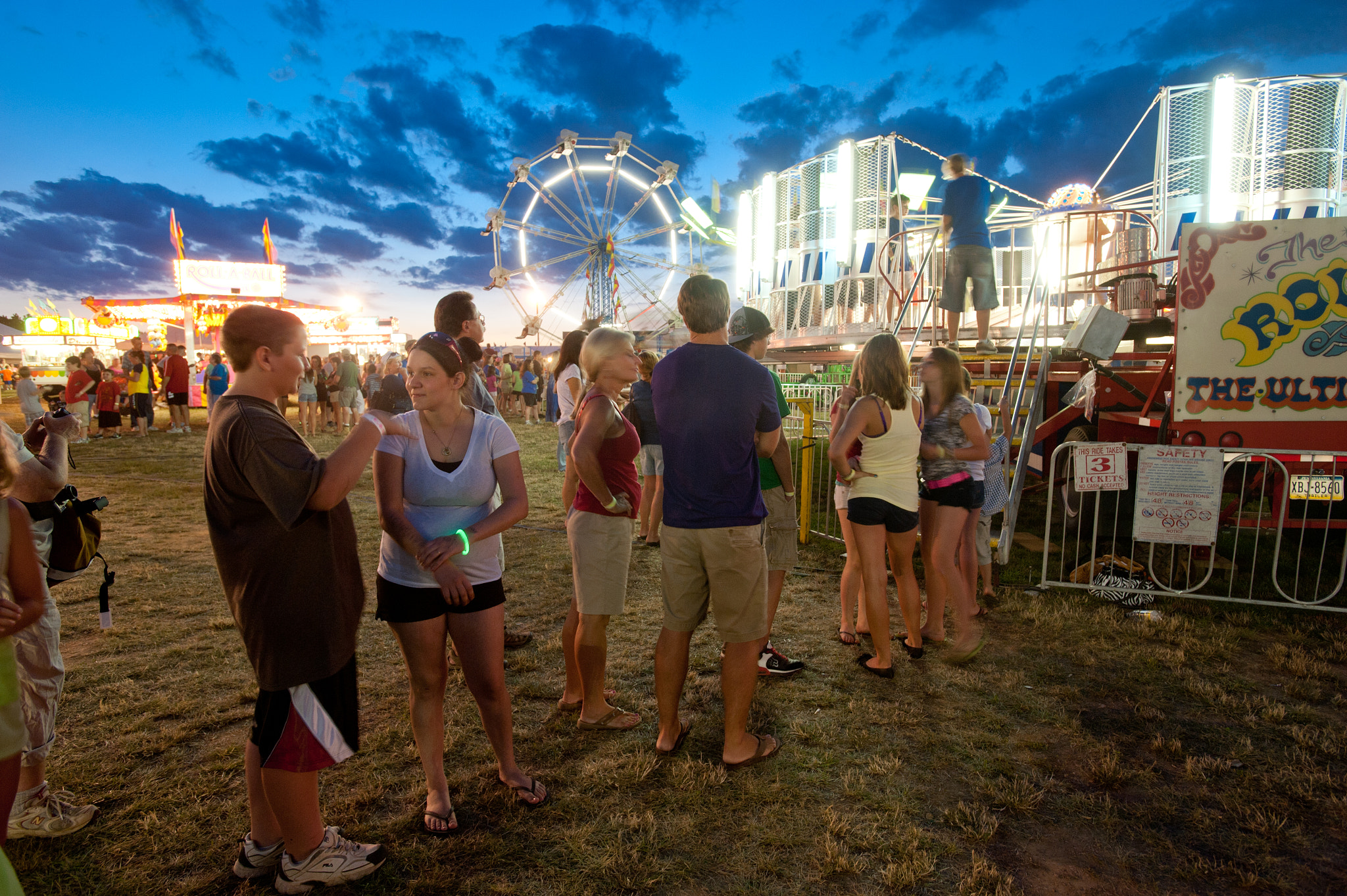 Nikon AF-S Nikkor 17-35mm F2.8D ED-IF sample photo. A line of people waiting for rides and lights in motion of ride at the mason dixon fair carnival photography
