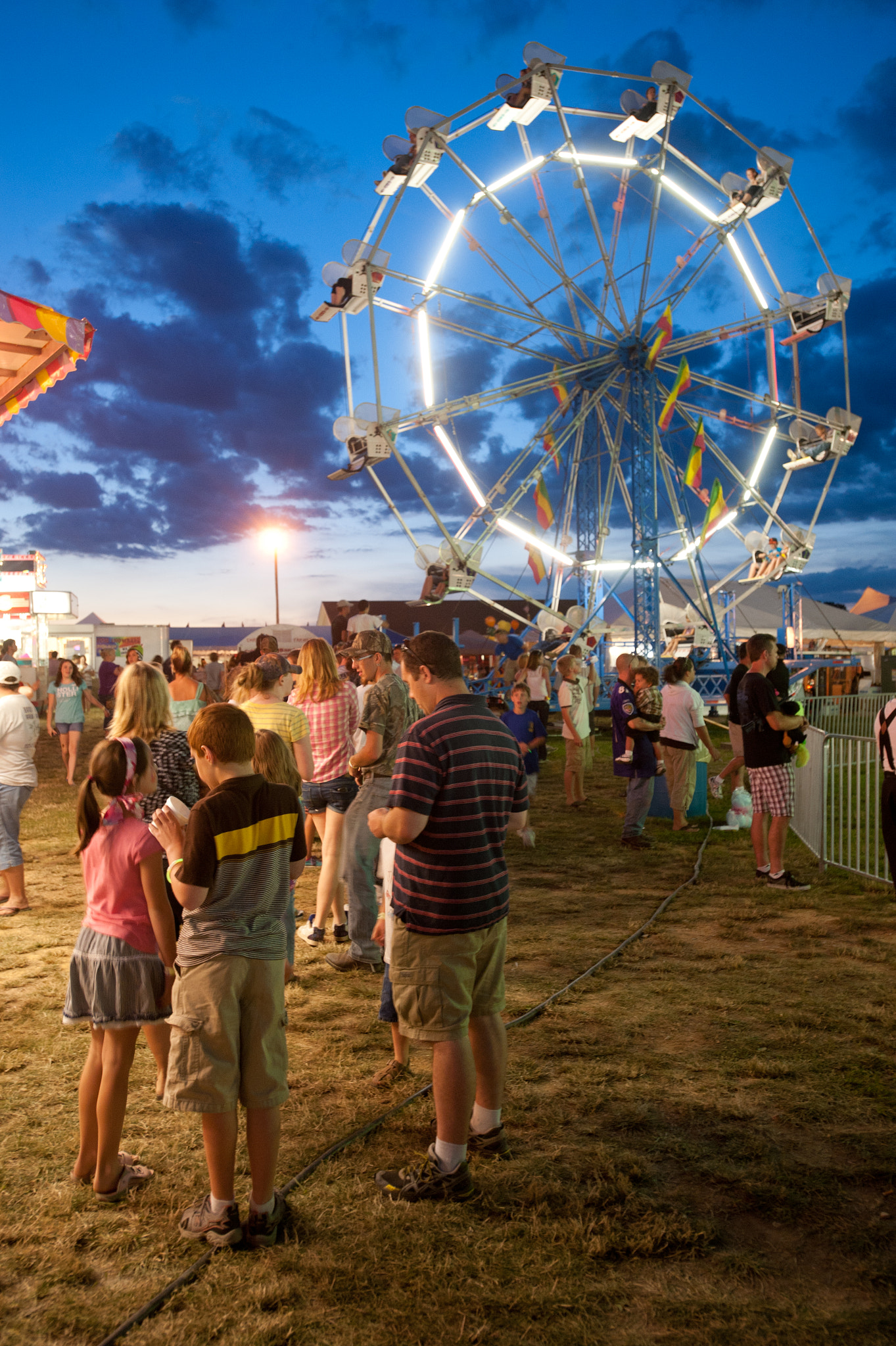 Nikon AF-S Nikkor 17-35mm F2.8D ED-IF sample photo. A line of people waiting for ferris wheel and lights in motion of ride at the mason dixon fair... photography