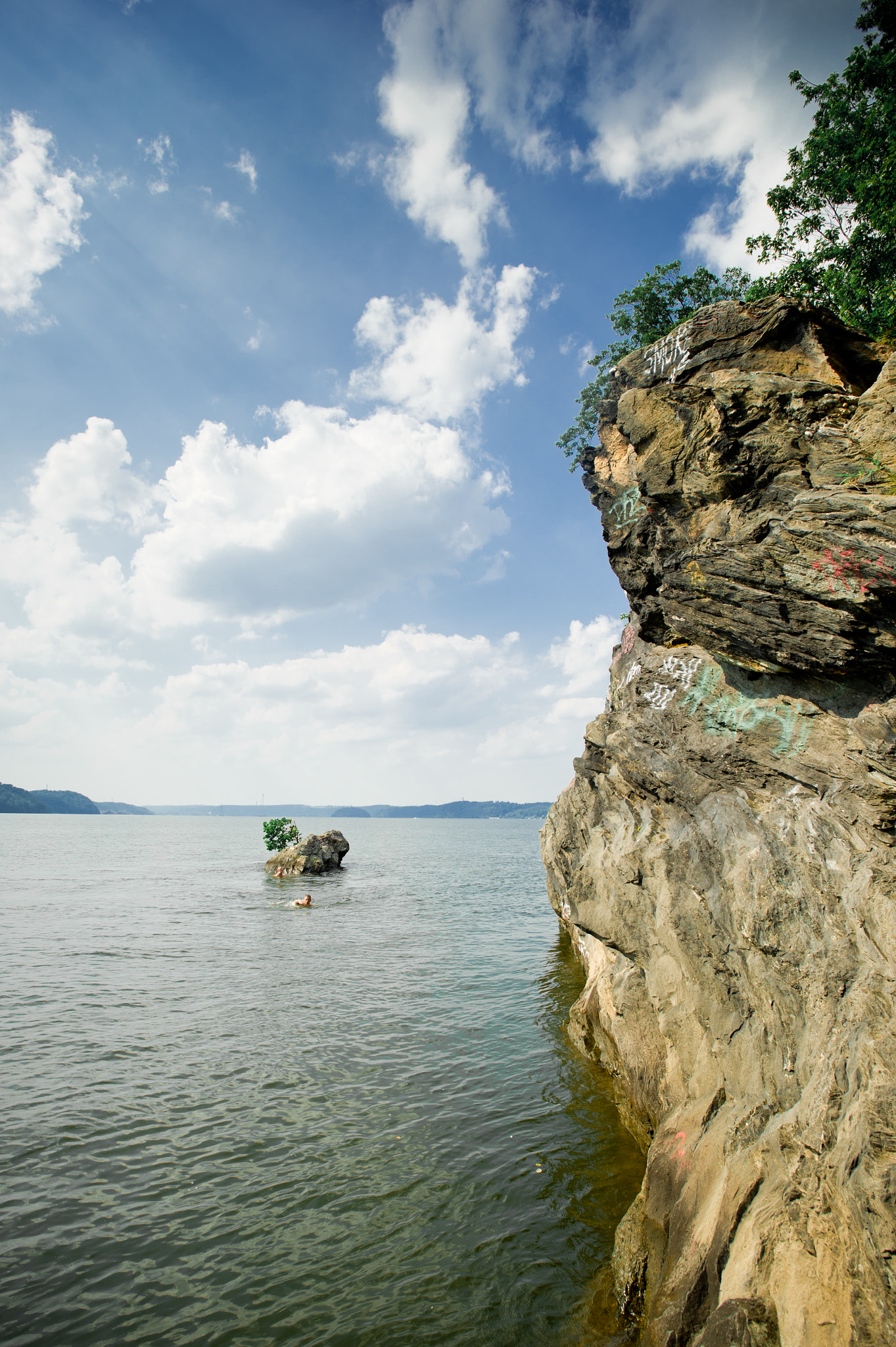 Nikon AF-S Nikkor 17-35mm F2.8D ED-IF sample photo. Cliff on the water under rays of sun peaking out of clouds of big blue sky in maryland near mason... photography