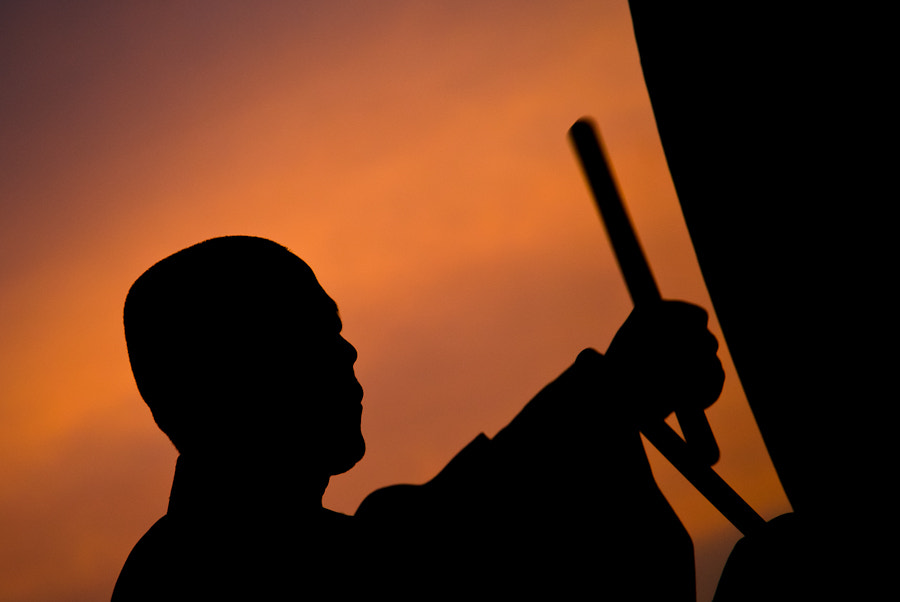 Nikon D200 sample photo. Korean monk hits the drum in sunset photography