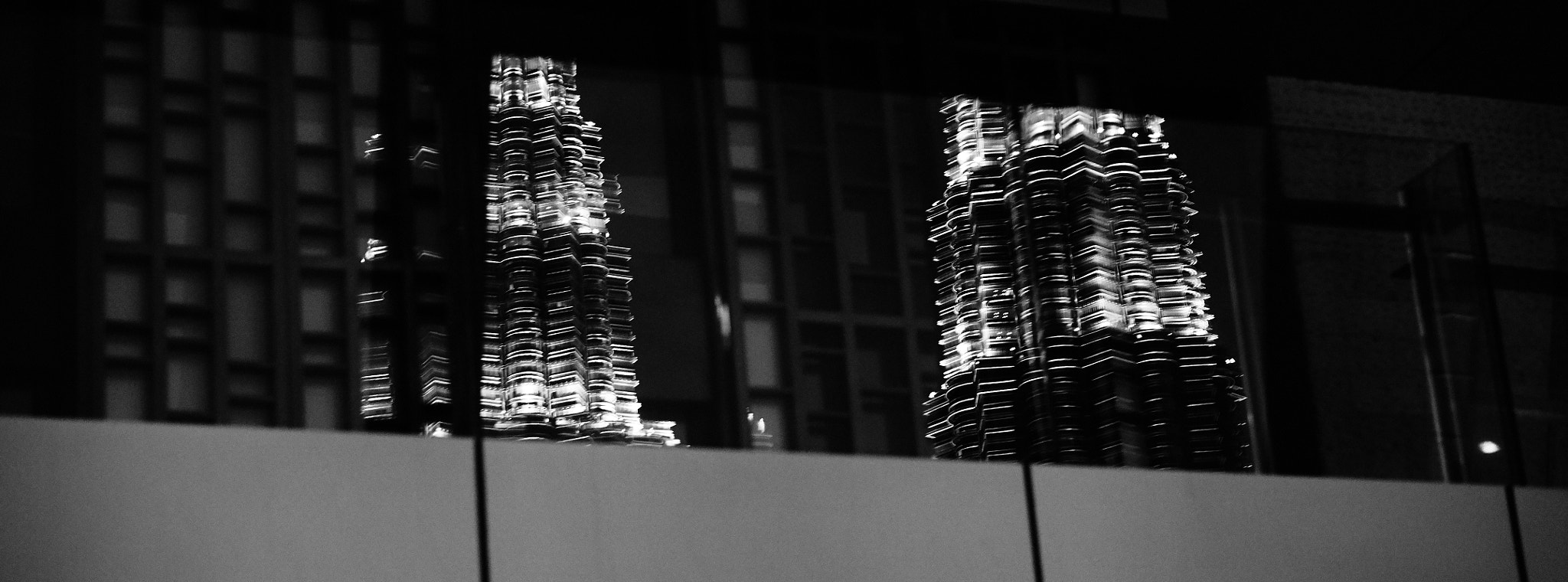 Sony E 50mm F1.8 OSS sample photo. Reflection of the petronas towers on a balkony photography