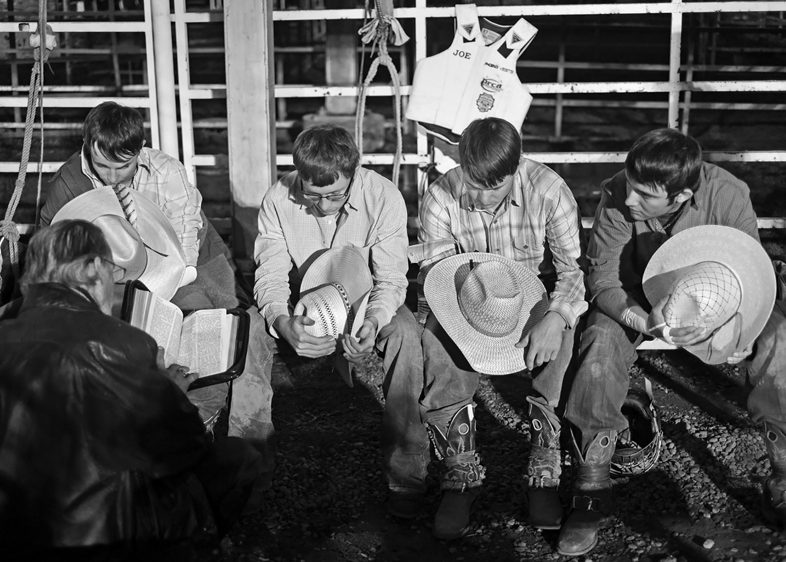 Fujifilm X-Pro1 + Fujifilm XF 35mm F1.4 R sample photo. Rodeo preacher reading to young bull riders photography
