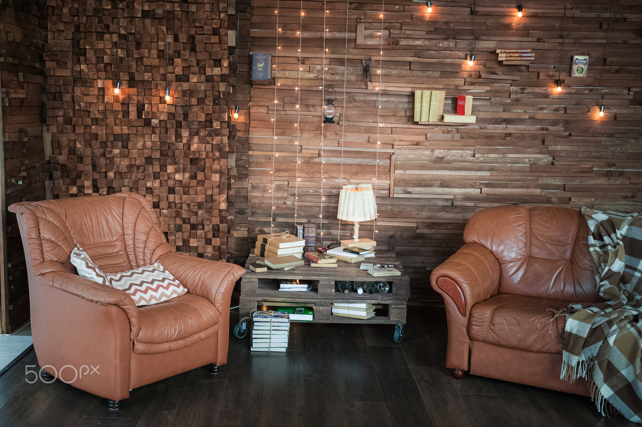 Cabinet in the loft style. Living room in ekostyle. Brown sofas, books and wooden beams