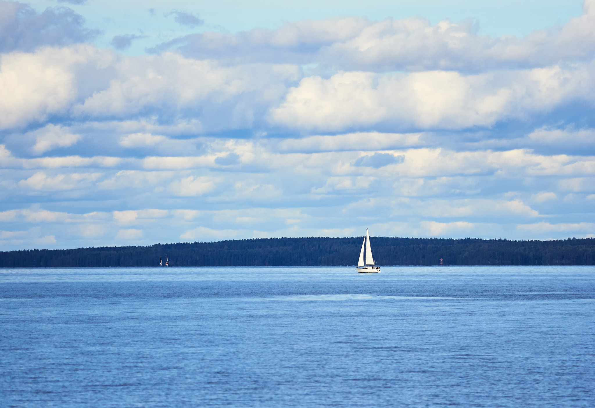 Olympus OM-D E-M5 II + Olympus M.Zuiko Digital ED 40-150mm F2.8 Pro sample photo. Small sailboat on the sea sailing to the horizon in summer photography